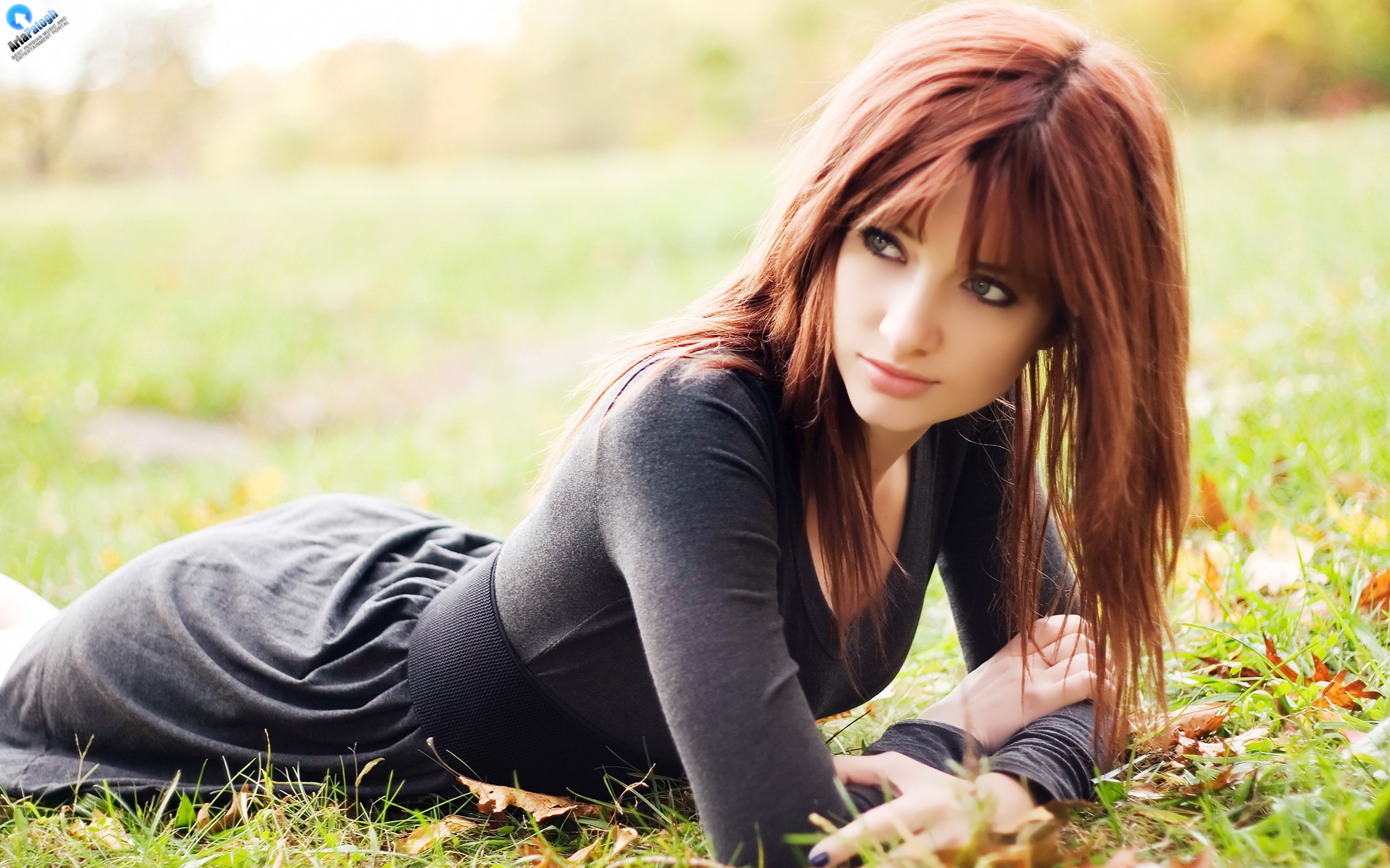 Susan Coffey with long red hair lying on grass HD Wallpaper