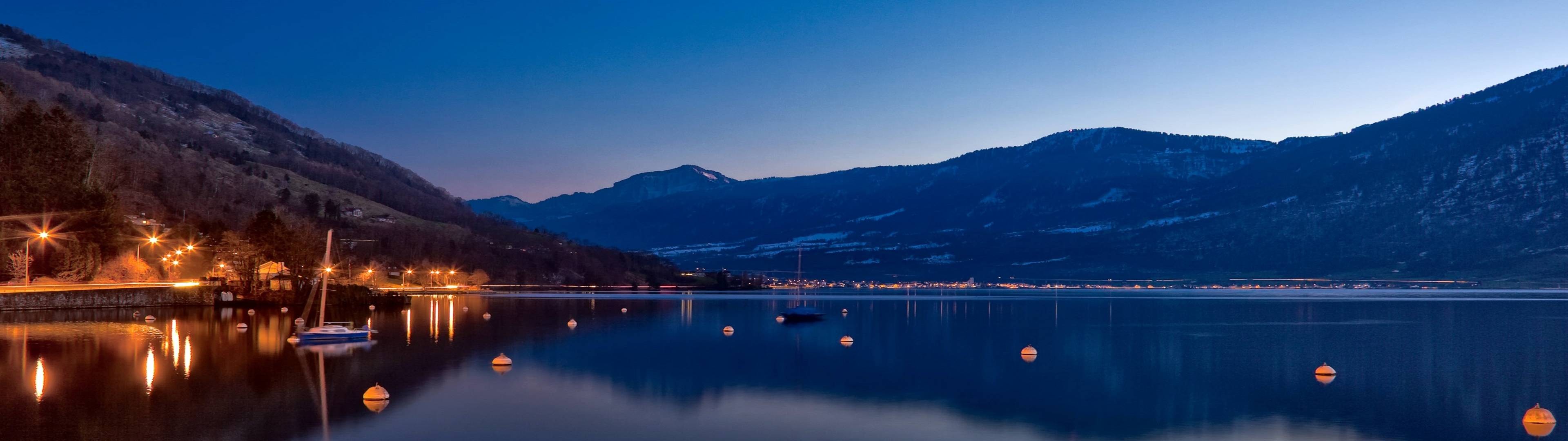 Lake Zug at dusk with mountains and lights HD Wallpaper