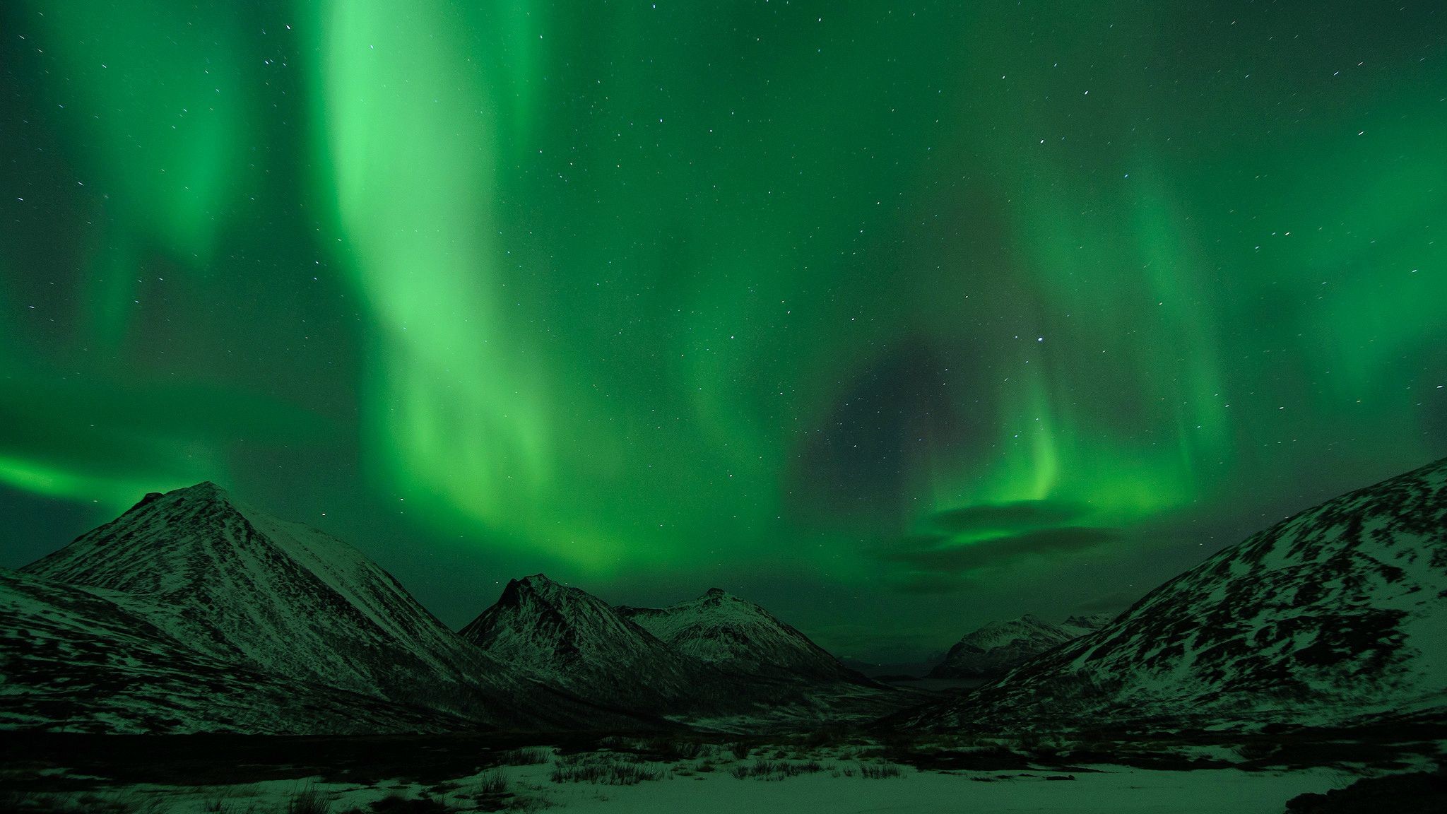 Aurora borealis over snow-covered mountains at night HD Wallpaper