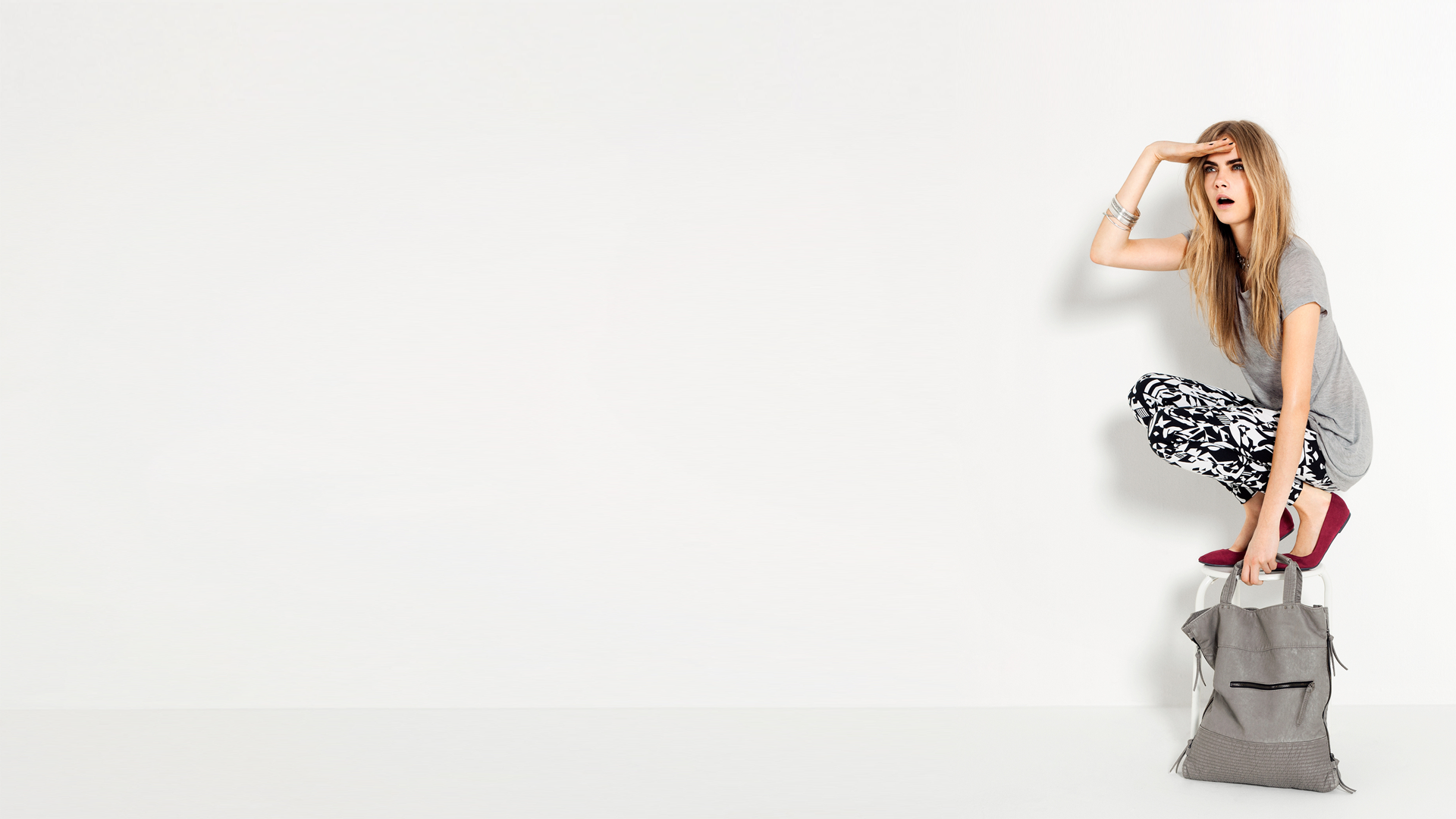 Cara Delevingne crouching on a backpack HD Wallpaper