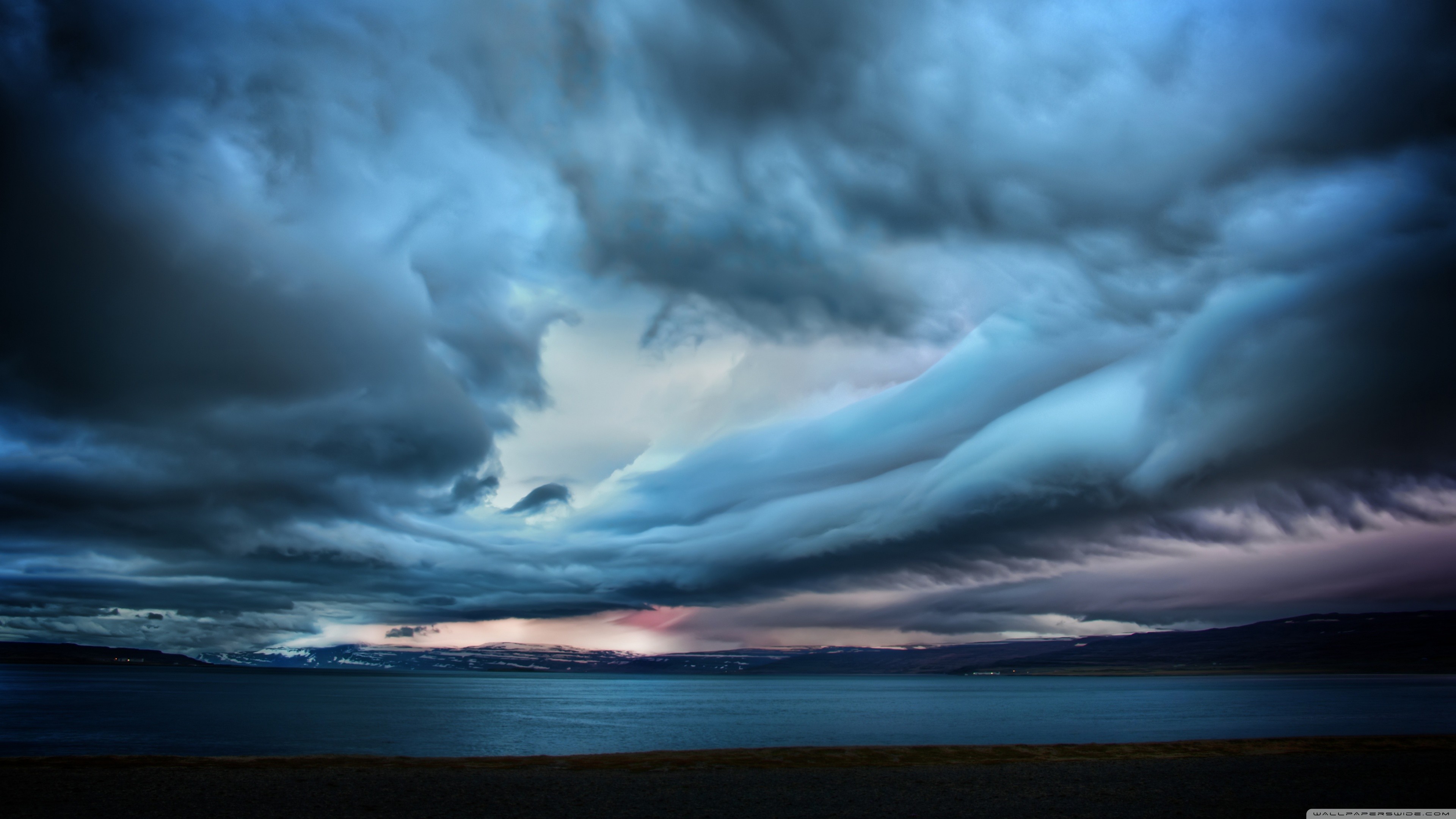 Dramatic storm clouds over a body of water HD Wallpaper
