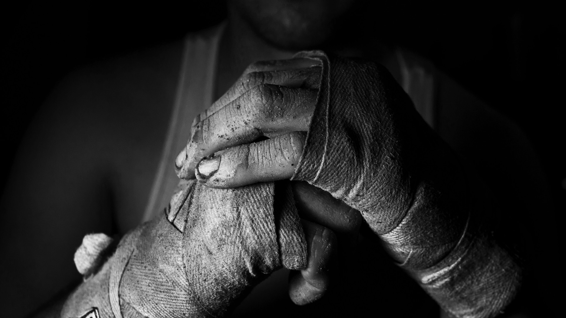 Monochrome close-up of boxer's hands wrapped in bandages HD Wallpaper