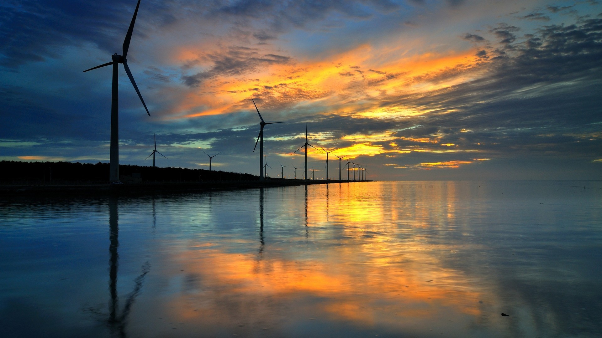 Wind turbines at sunset reflected in the water HD Wallpaper