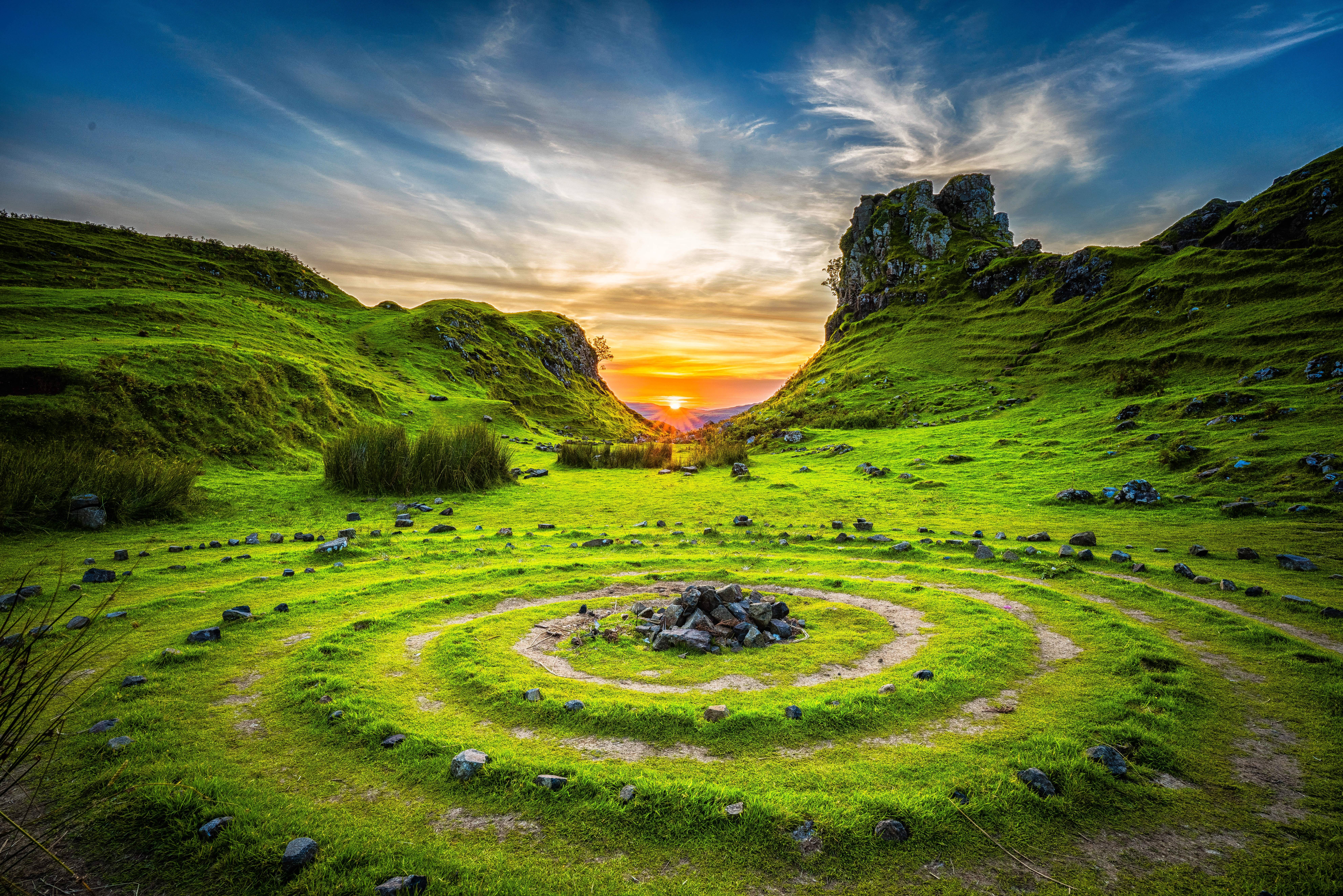 Stone circles in a green valley at sunset HD Wallpaper