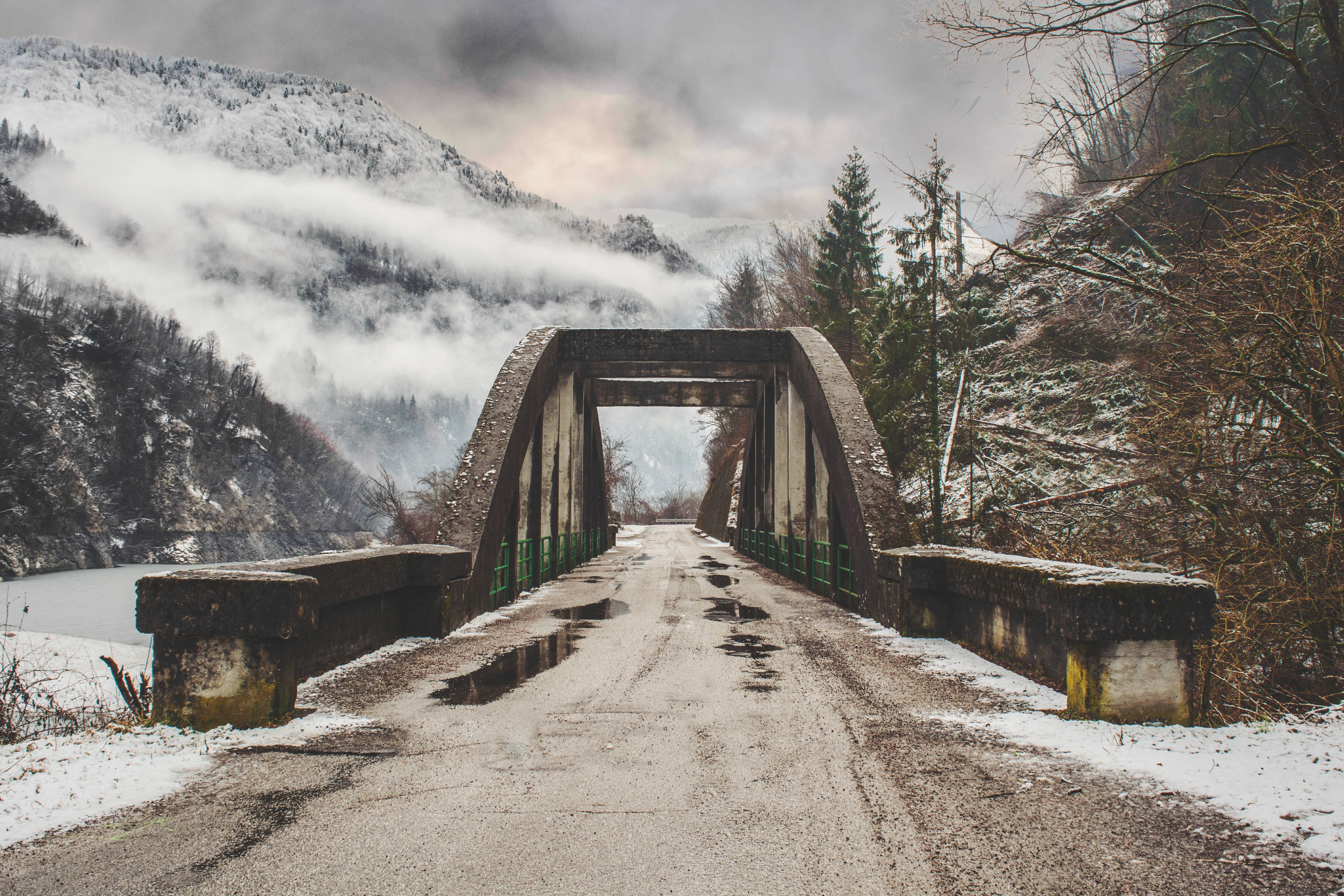 Concrete bridge over a misty mountain road in winter HD Wallpaper