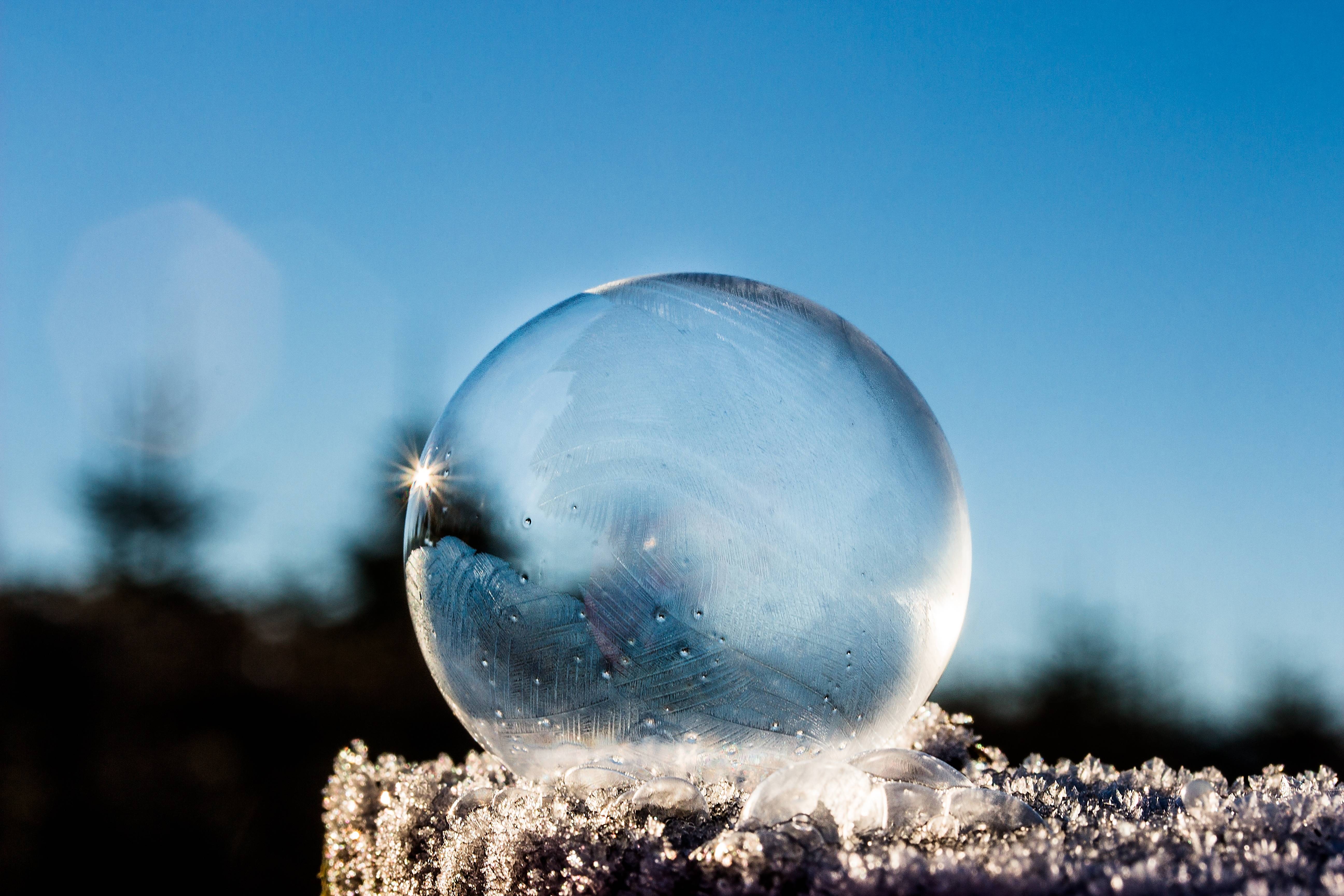 Frozen soap bubble with sunbeam on frosty surface HD Wallpaper