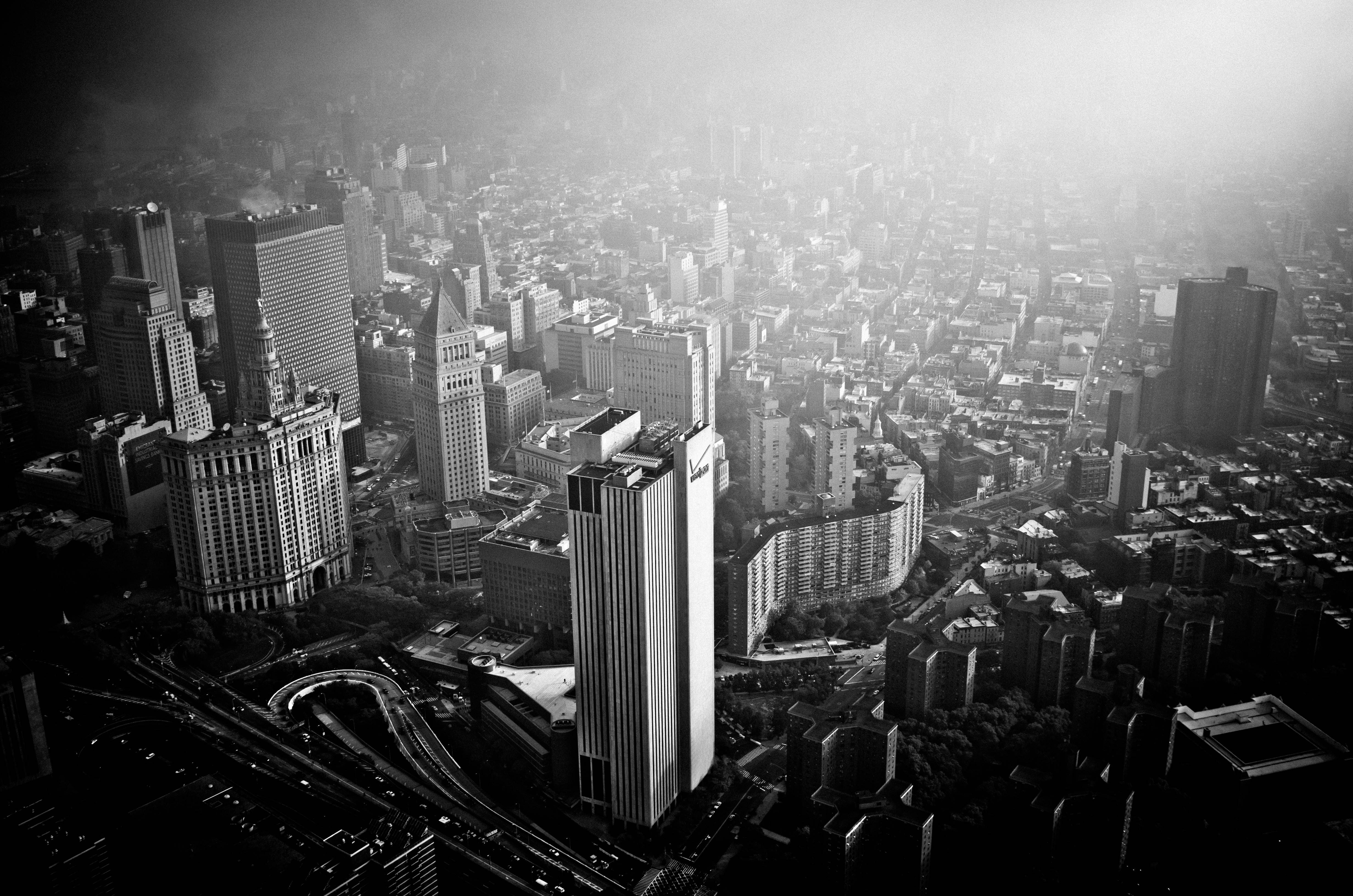 Black and white aerial view of a dense cityscape with tall buildings. HD Wallpaper