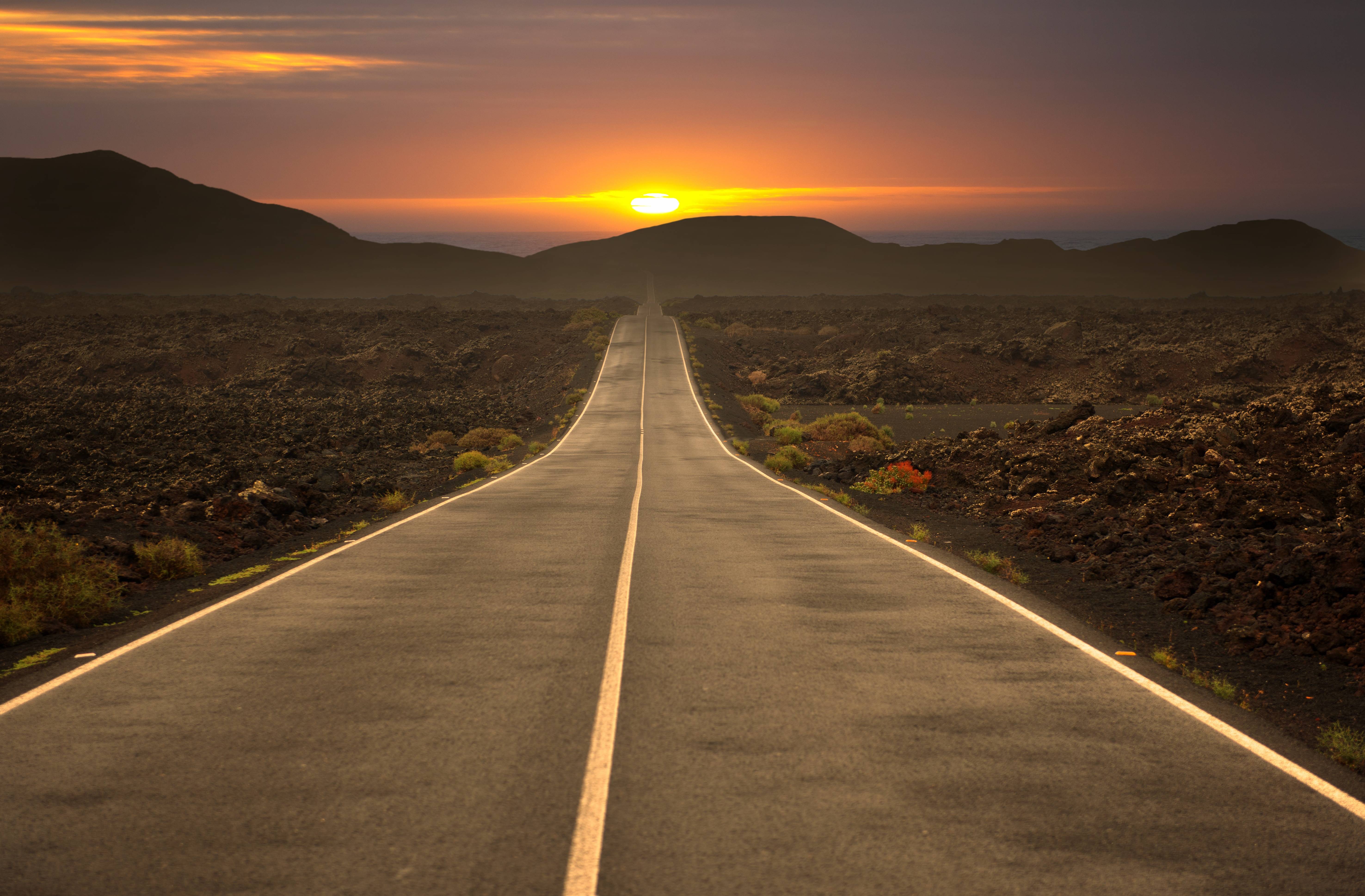 Road through a volcanic landscape at sunset HD Wallpaper