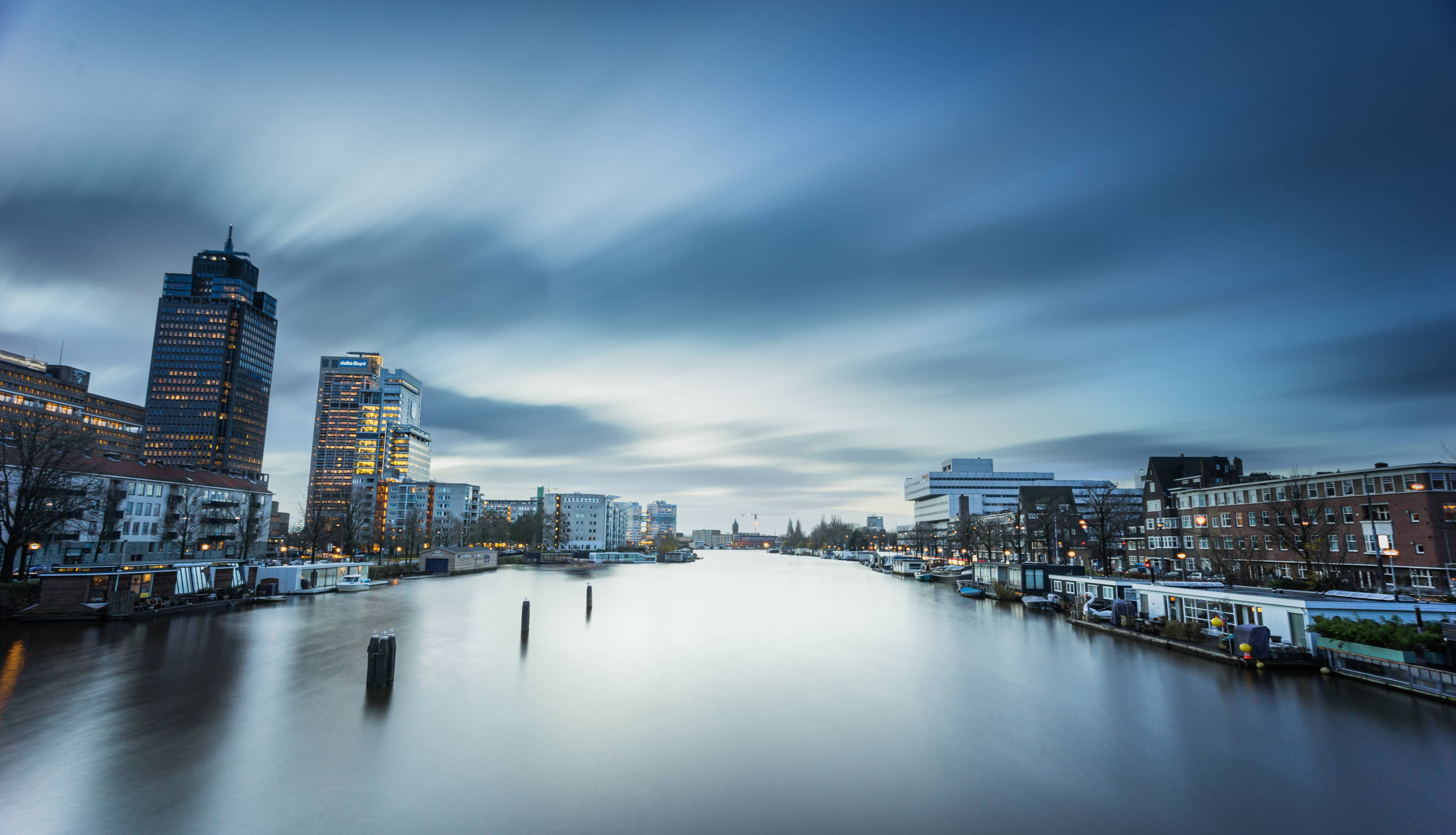 Cityscape with river and buildings at dusk HD Wallpaper