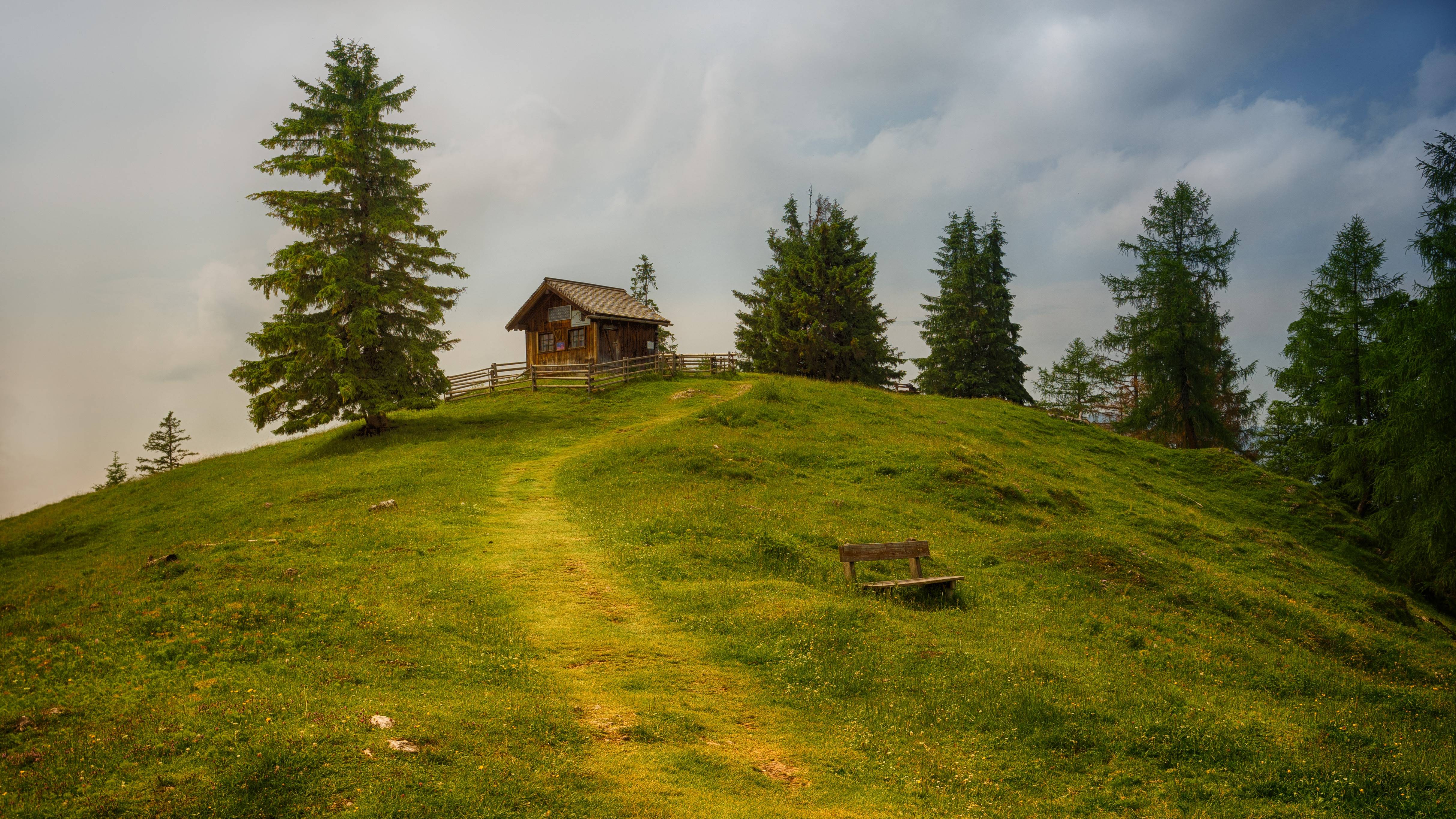 Solitary Hut on a Grassy Hill Under Cloudy Sky HD Wallpaper