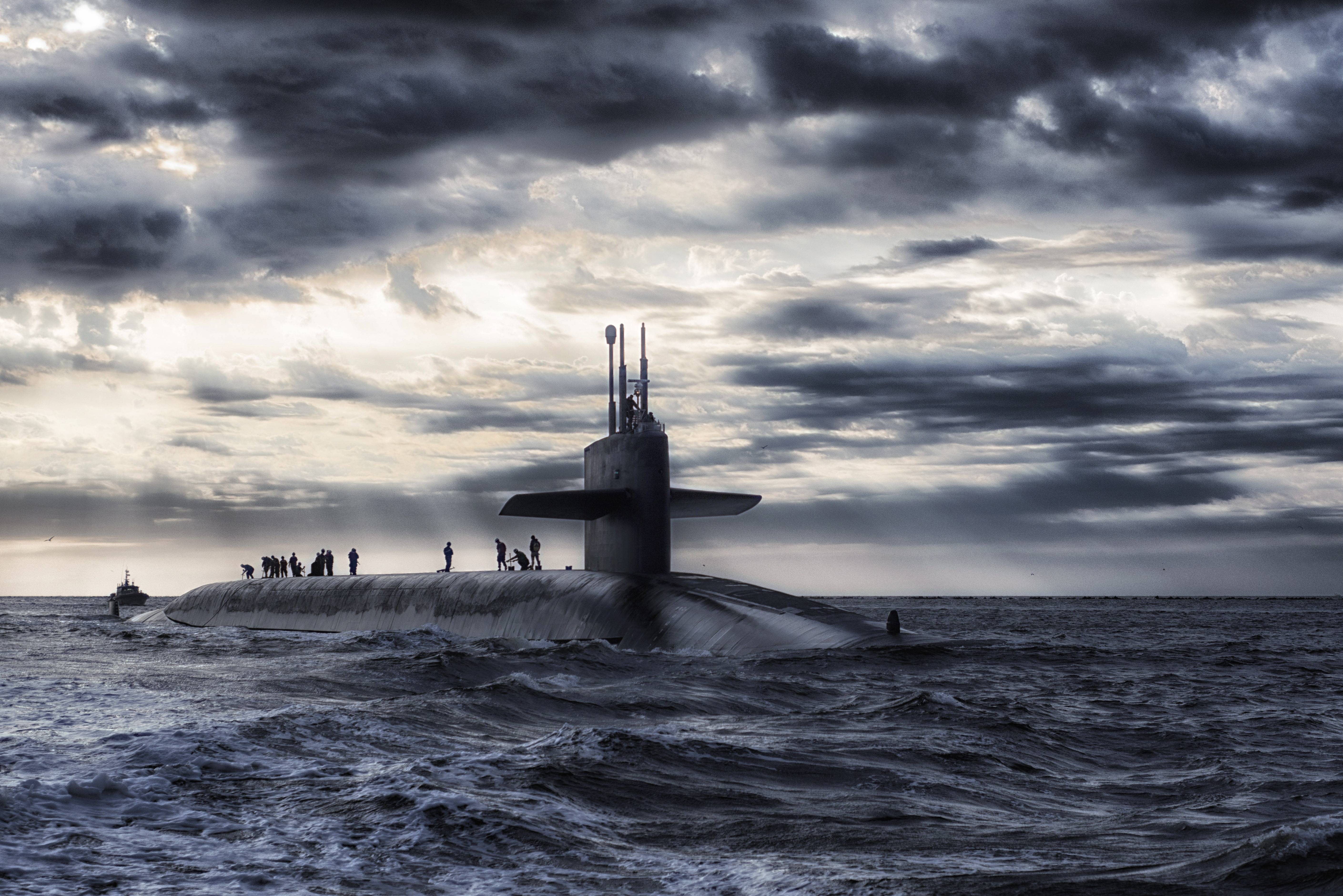 Submarine sailing on a stormy sea under dramatic clouds HD Wallpaper