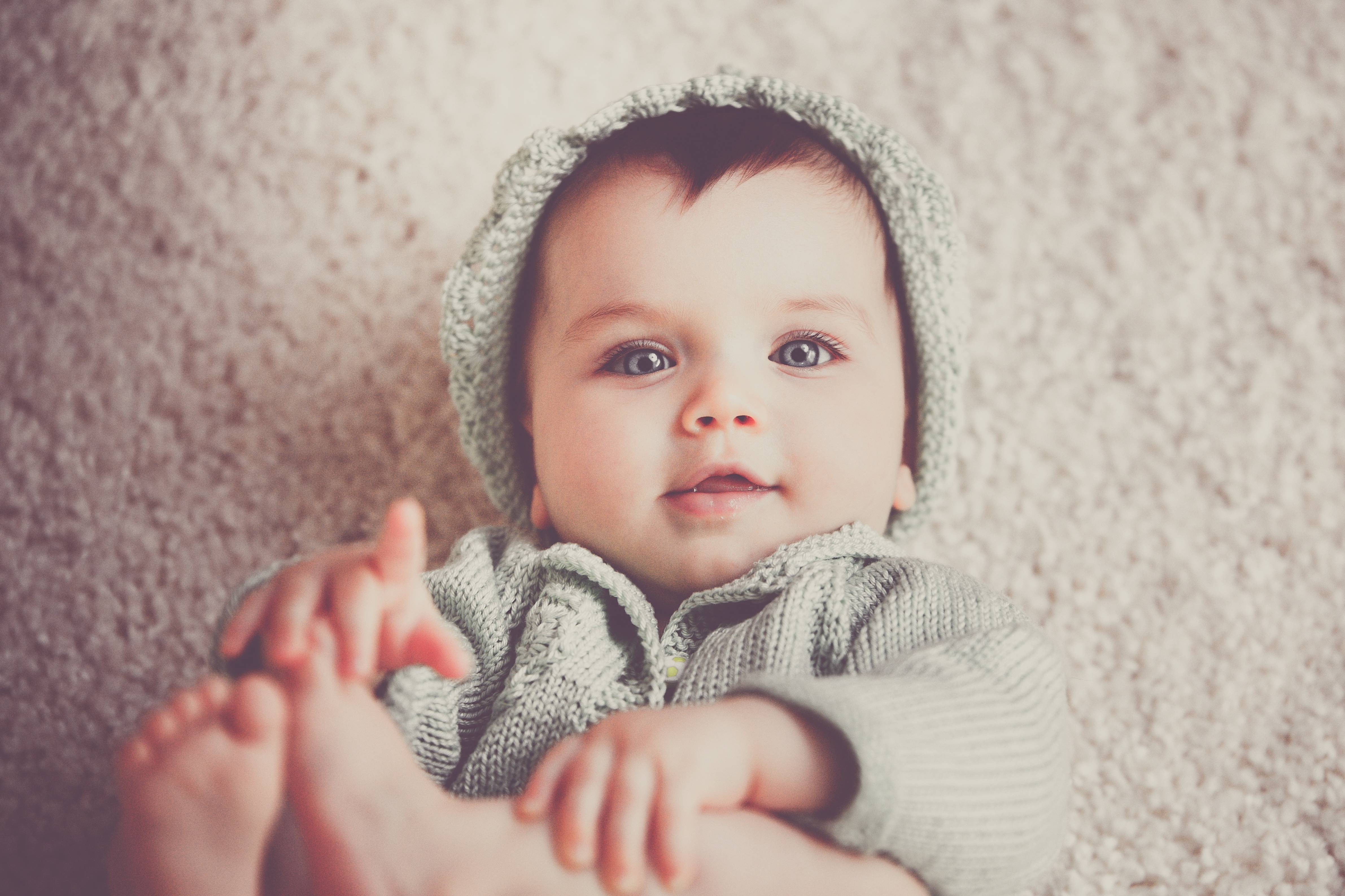 Baby wearing a knitted cap and jacket HD Wallpaper