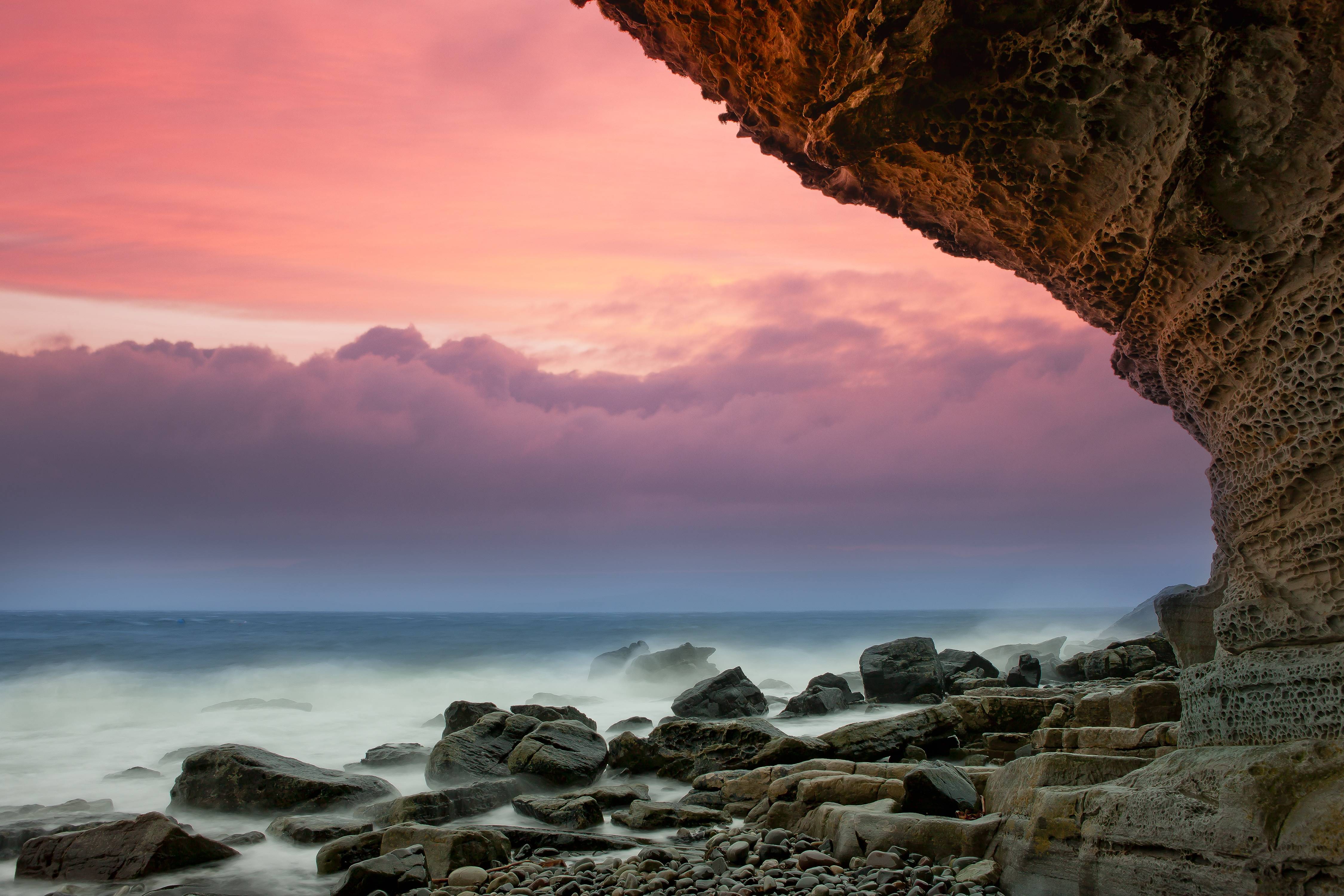 Rocky coast with pink and purple sunset sky HD Wallpaper