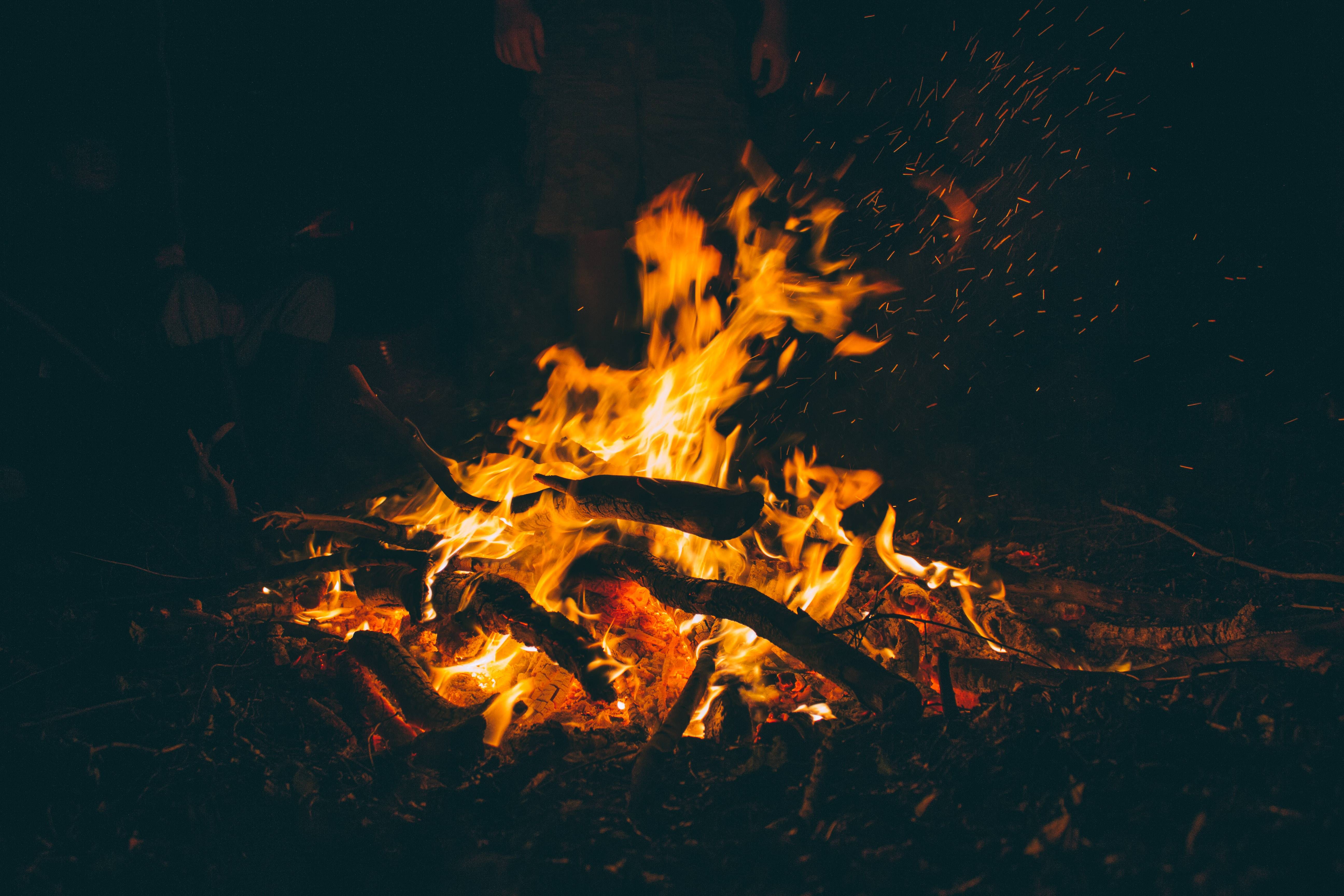 Campfire burning at night with sparks HD Wallpaper