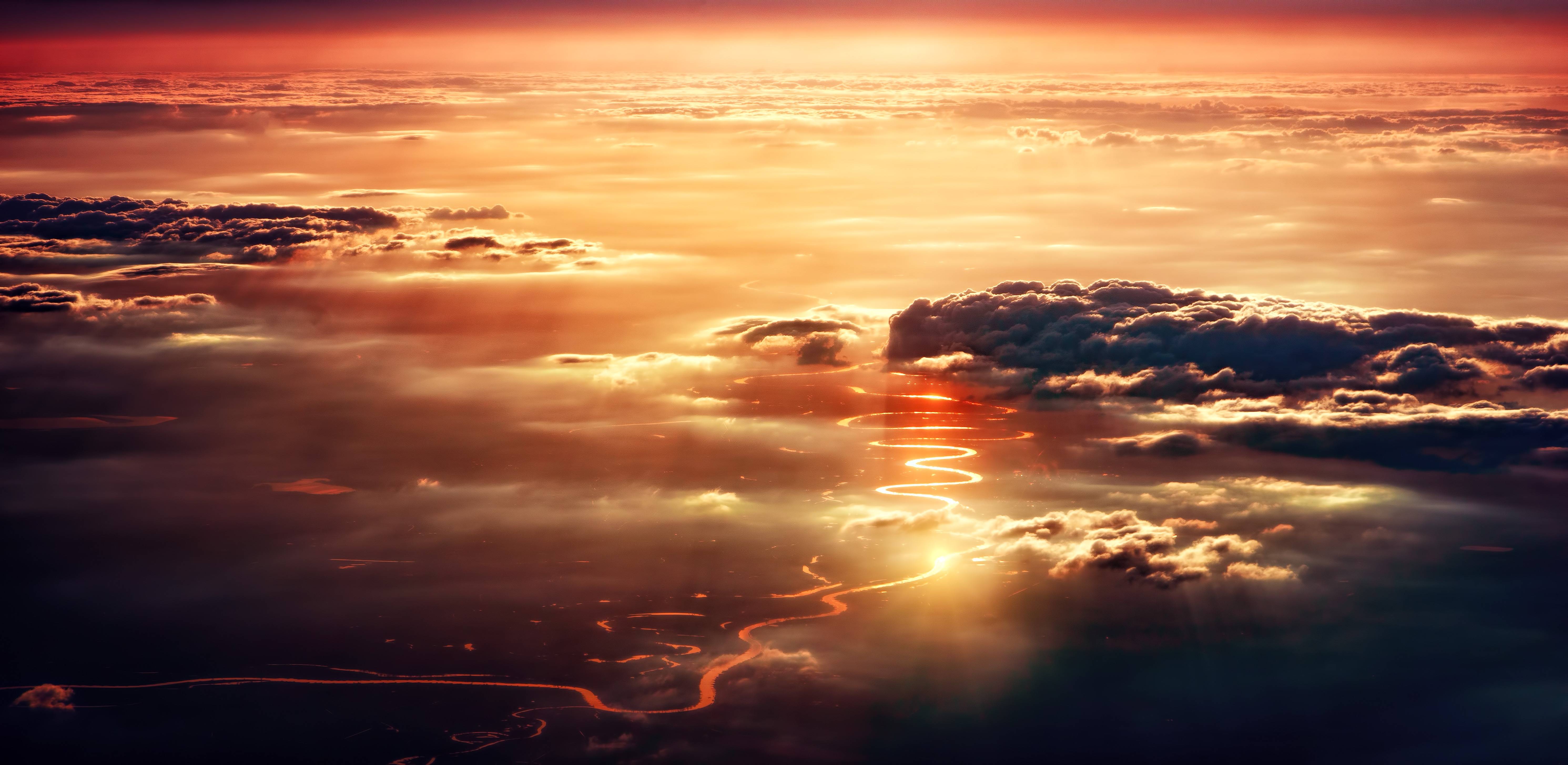 Sunset over clouds with a winding river below HD Wallpaper