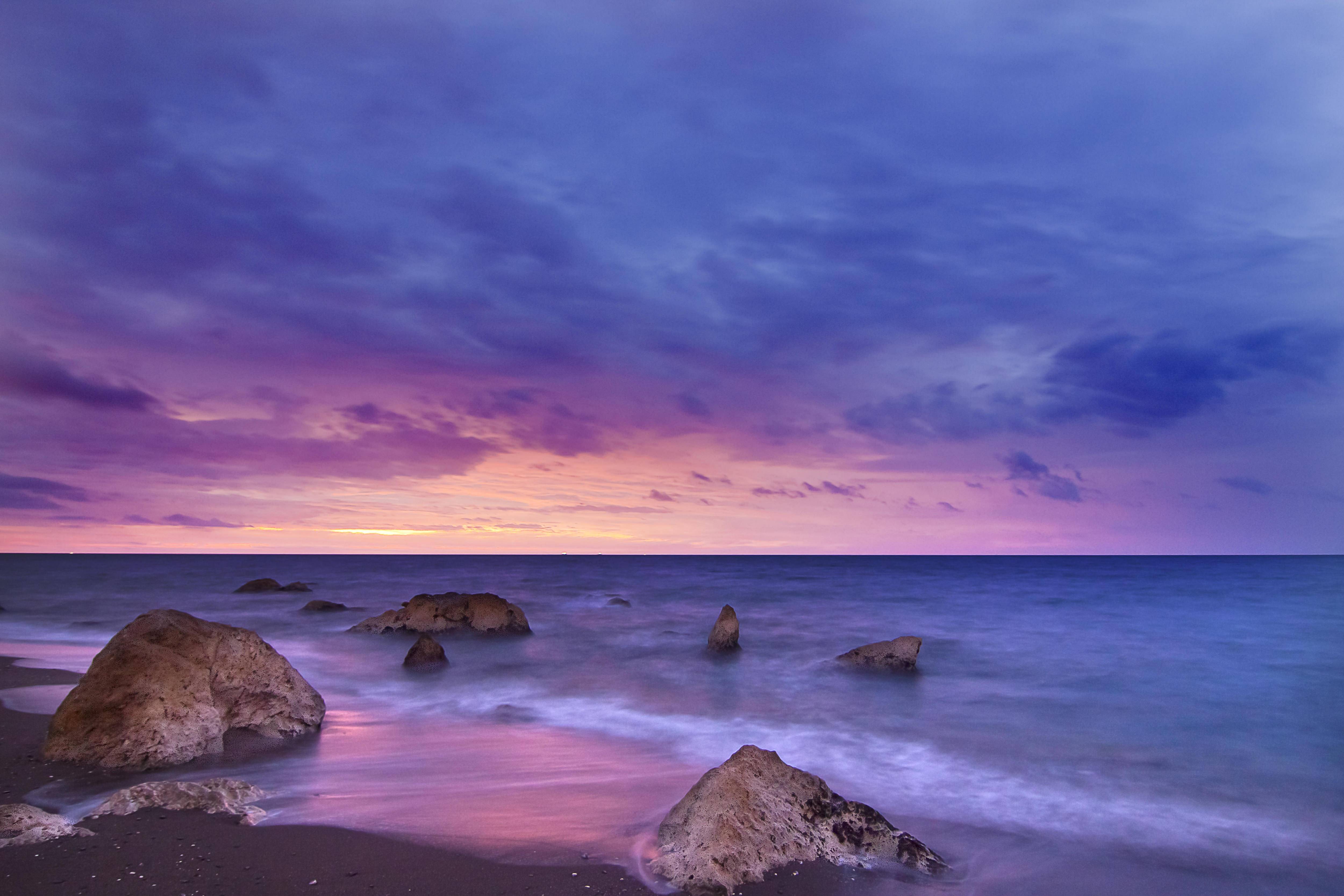 Ocean rocks at dusk with purple and pink clouds HD Wallpaper