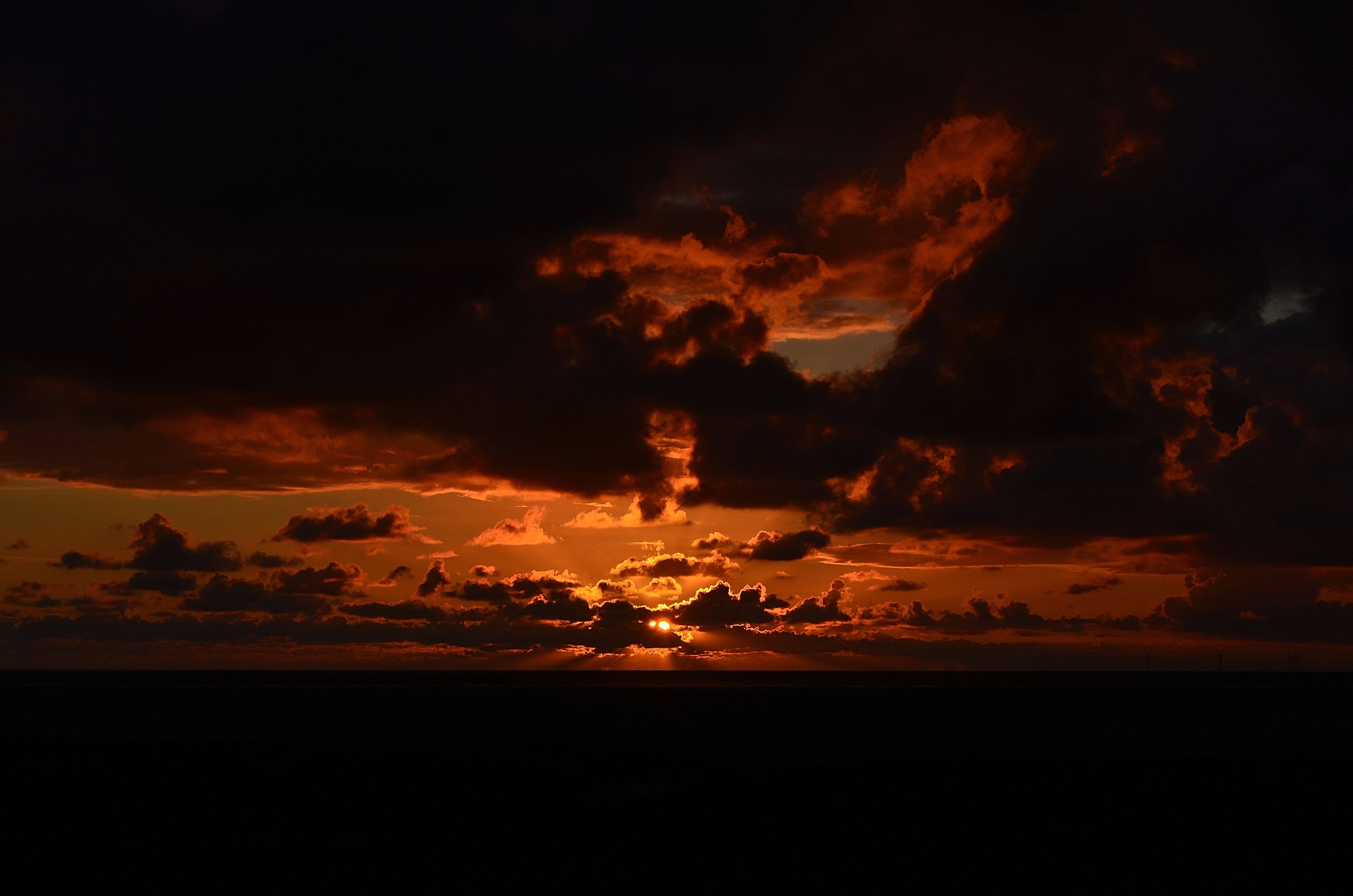 Sunset over the ocean with dramatic clouds HD Wallpaper