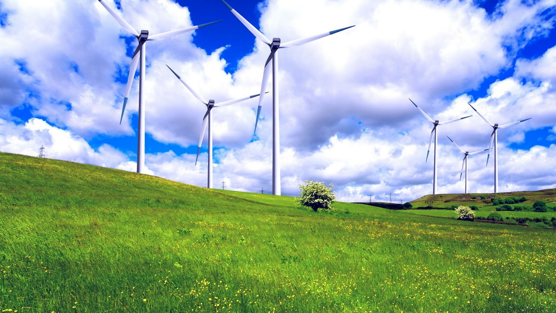 Wind turbines on a grassy hill under a cloudy sky HD Wallpaper