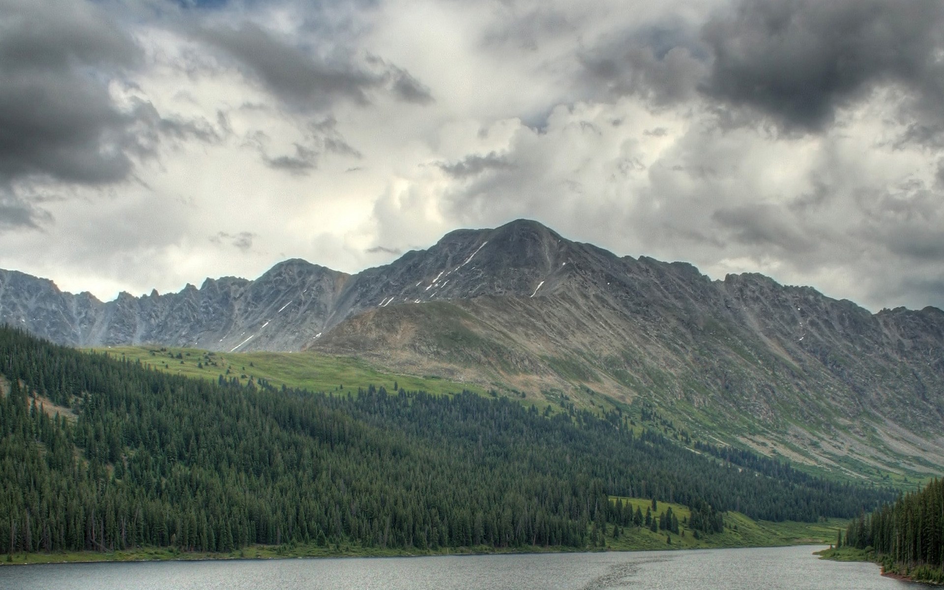 Mountain range with lake and forest under cloudy sky HD Wallpaper