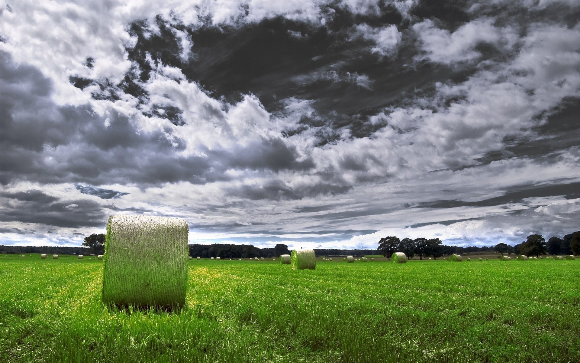 Hay bales in a green field under a cloudy sky HD Wallpaper