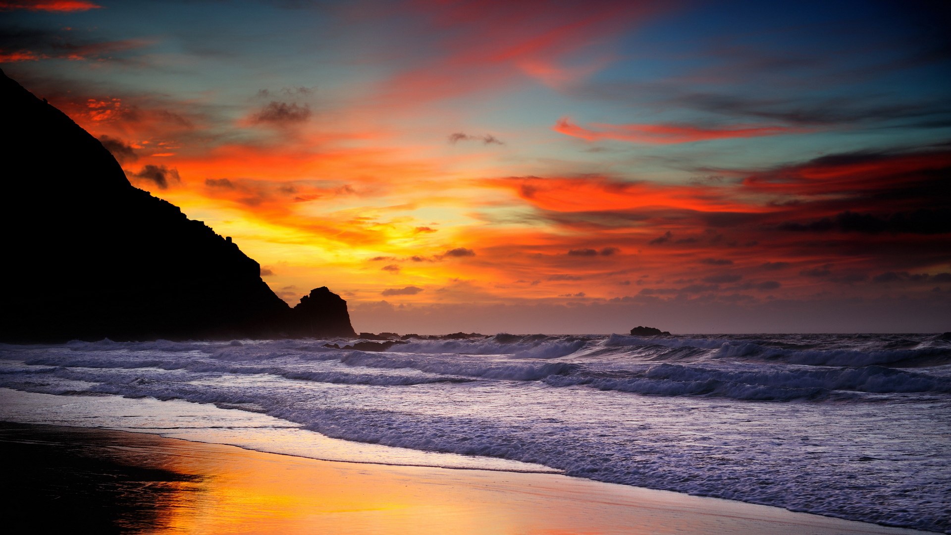 Sunset over a rocky beach with crashing waves HD Wallpaper