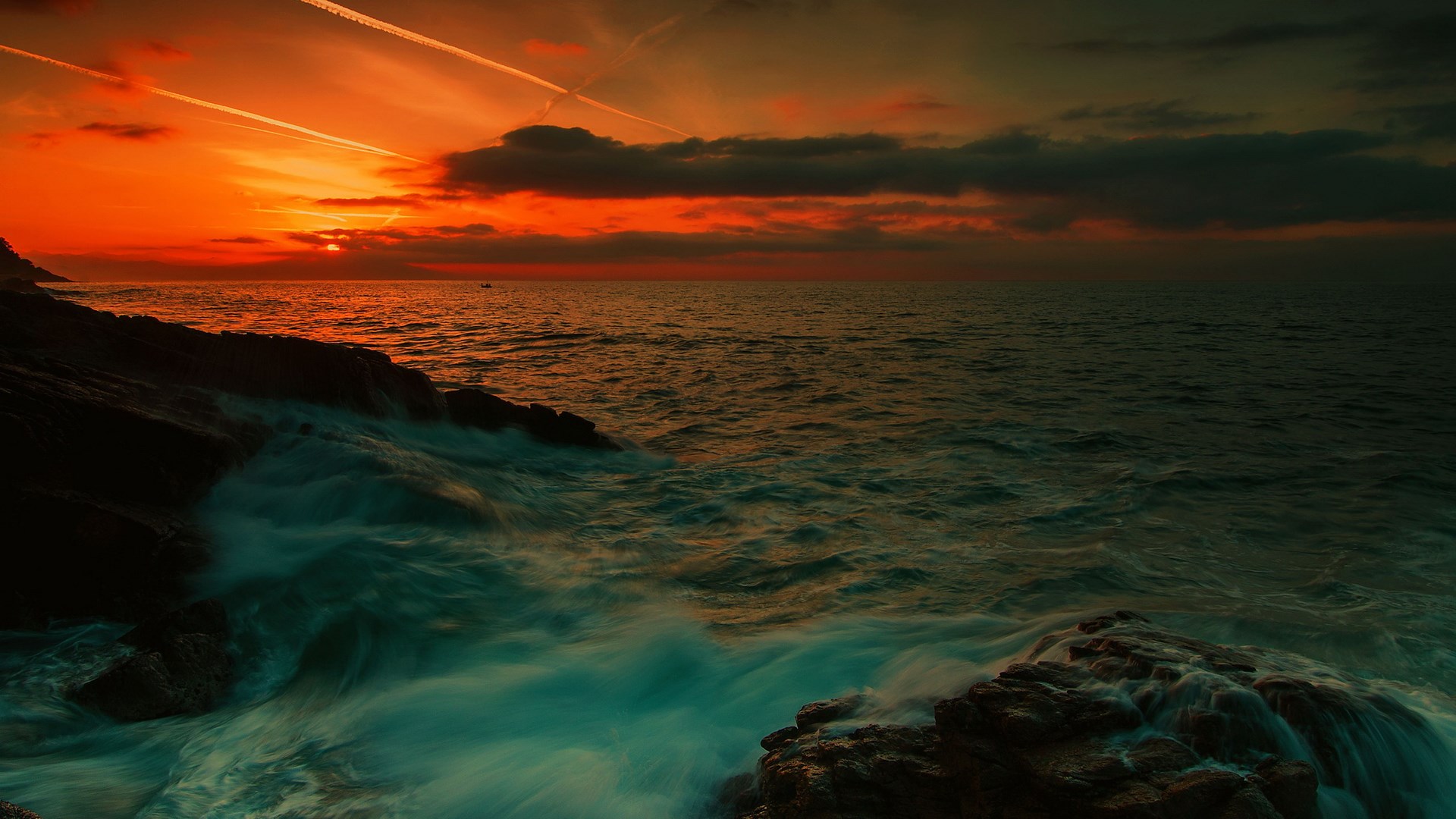 Sunset over the ocean with waves crashing on rocks HD Wallpaper