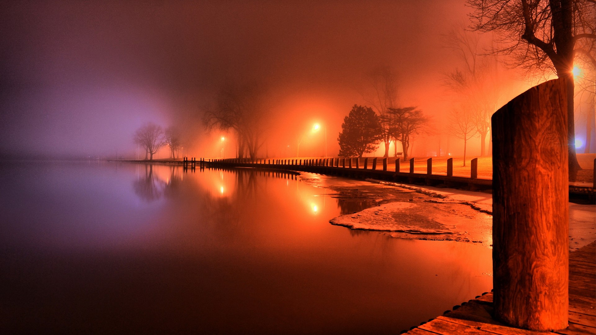 Foggy night by a lake with streetlights HD Wallpaper