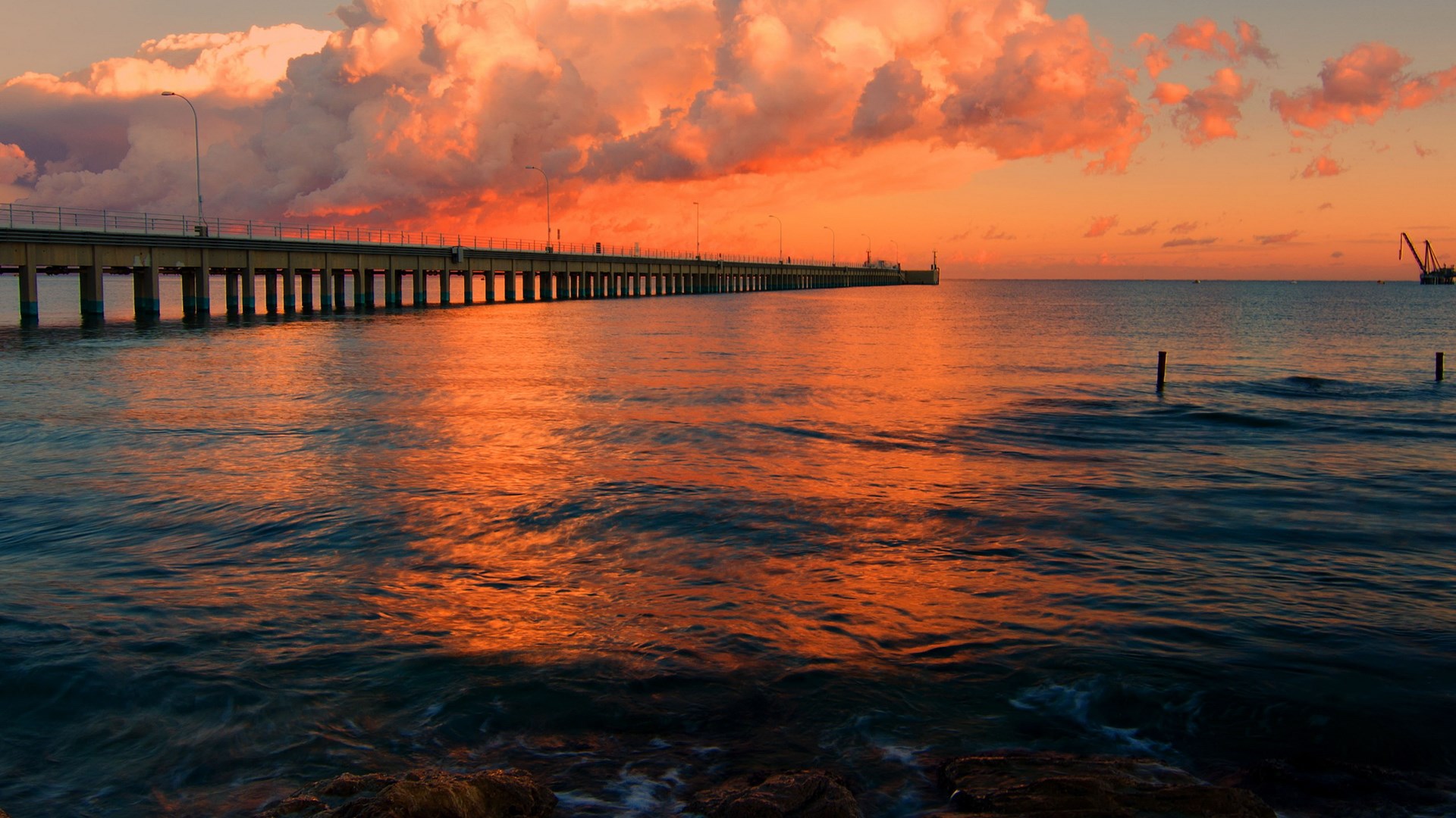 Pier and ocean at sunset with clouds and crane HD Wallpaper