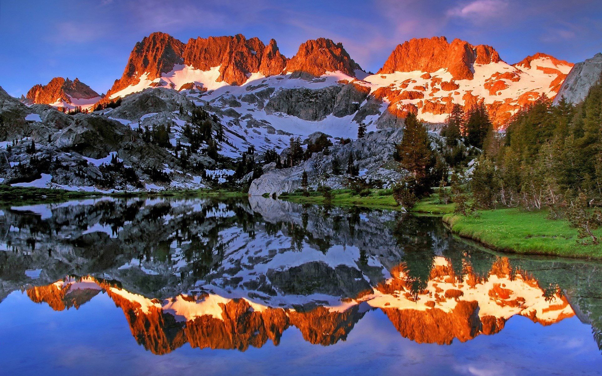 Mountain range reflected in a lake at sunrise HD Wallpaper