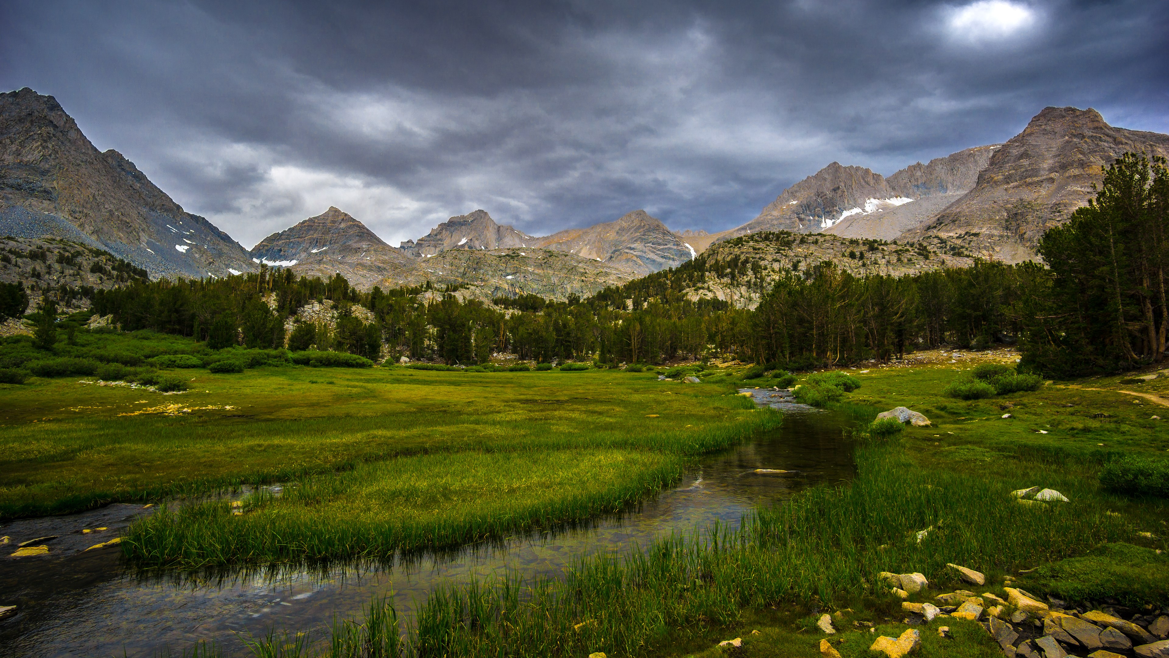 Mountain landscape with stream and stormy sky HD Wallpaper