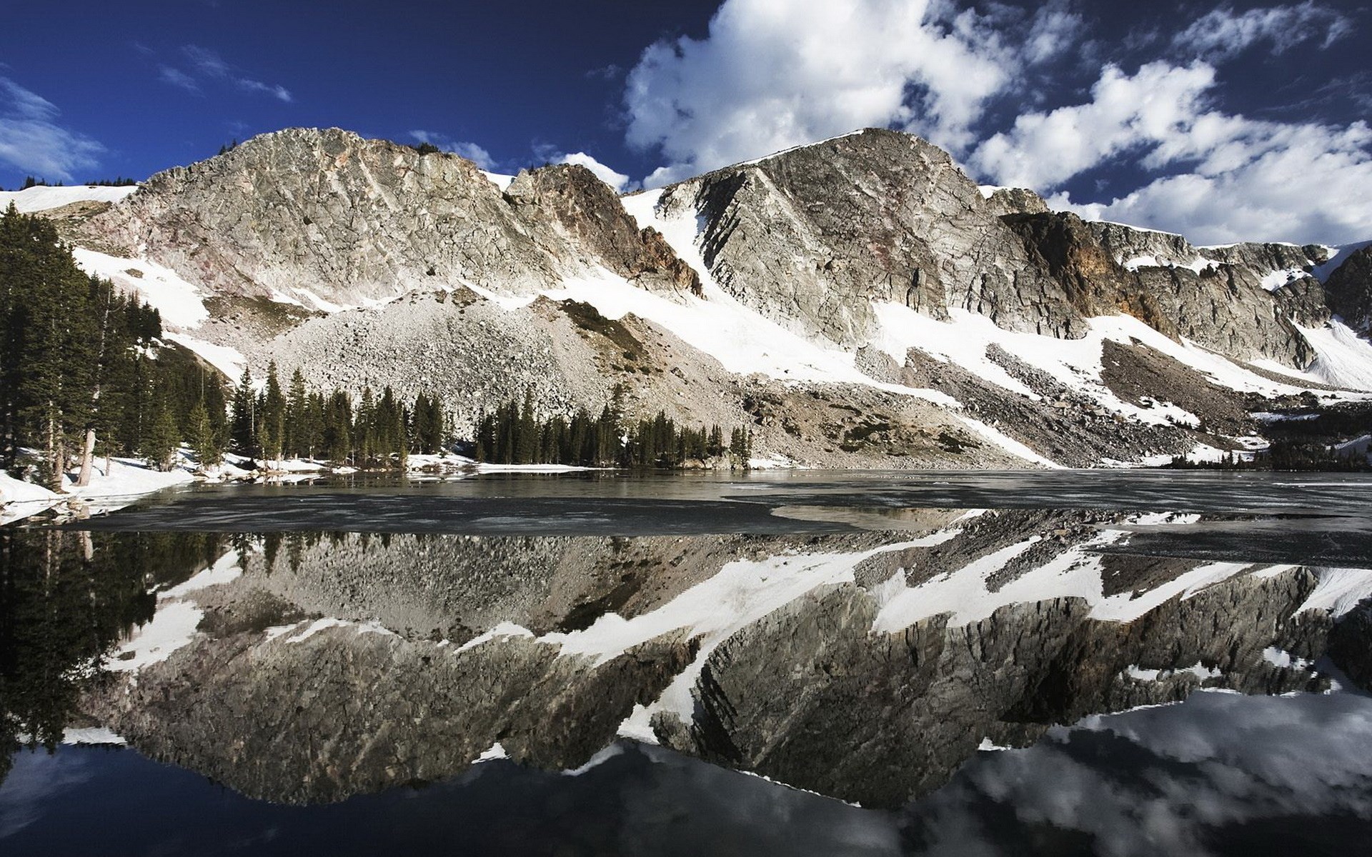 Snow-capped mountains reflected in a calm lake HD Wallpaper