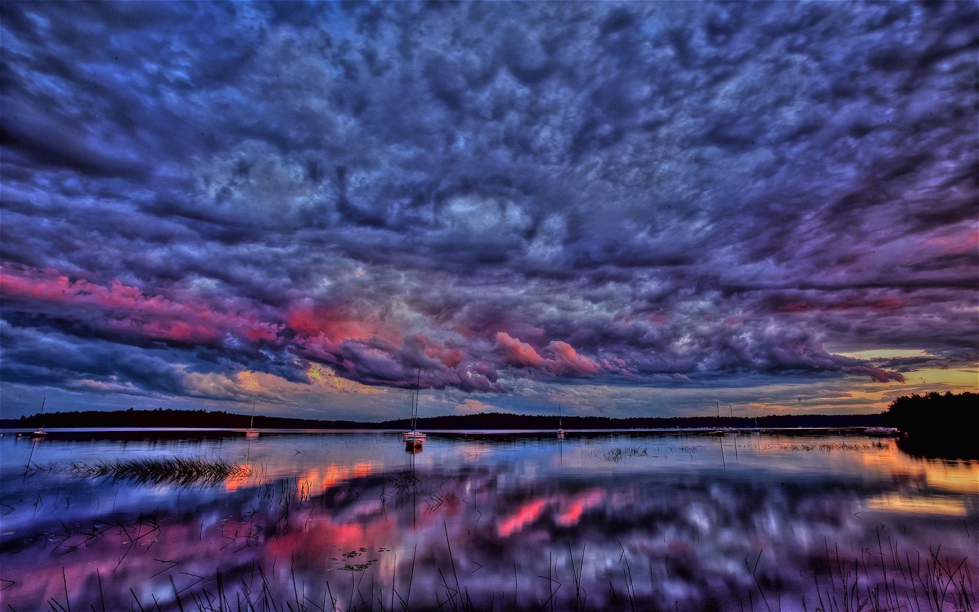 Dramatic sunset over a calm lake with sailboats HD Wallpaper