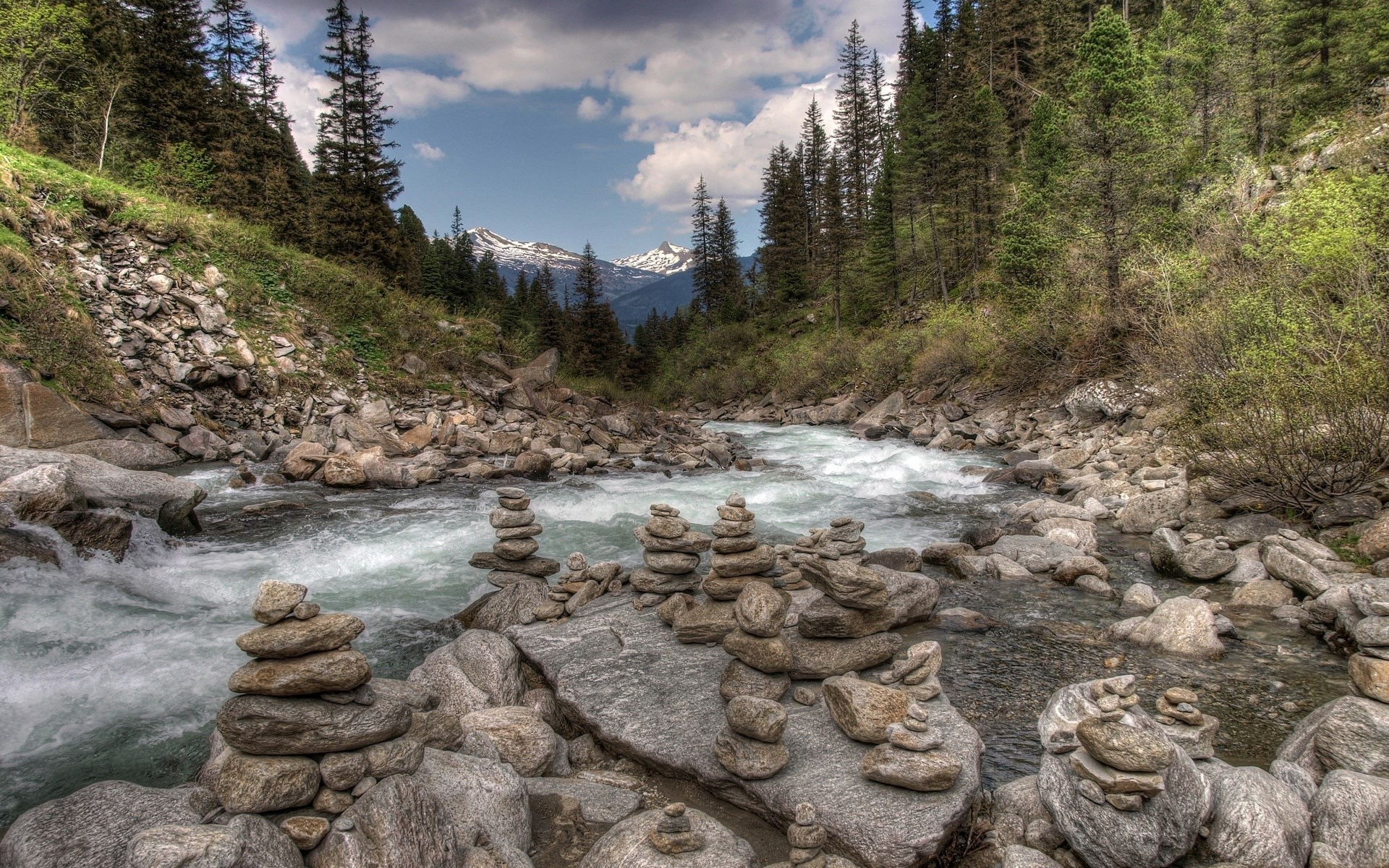 River flowing through a rocky mountain landscape with cairns HD Wallpaper