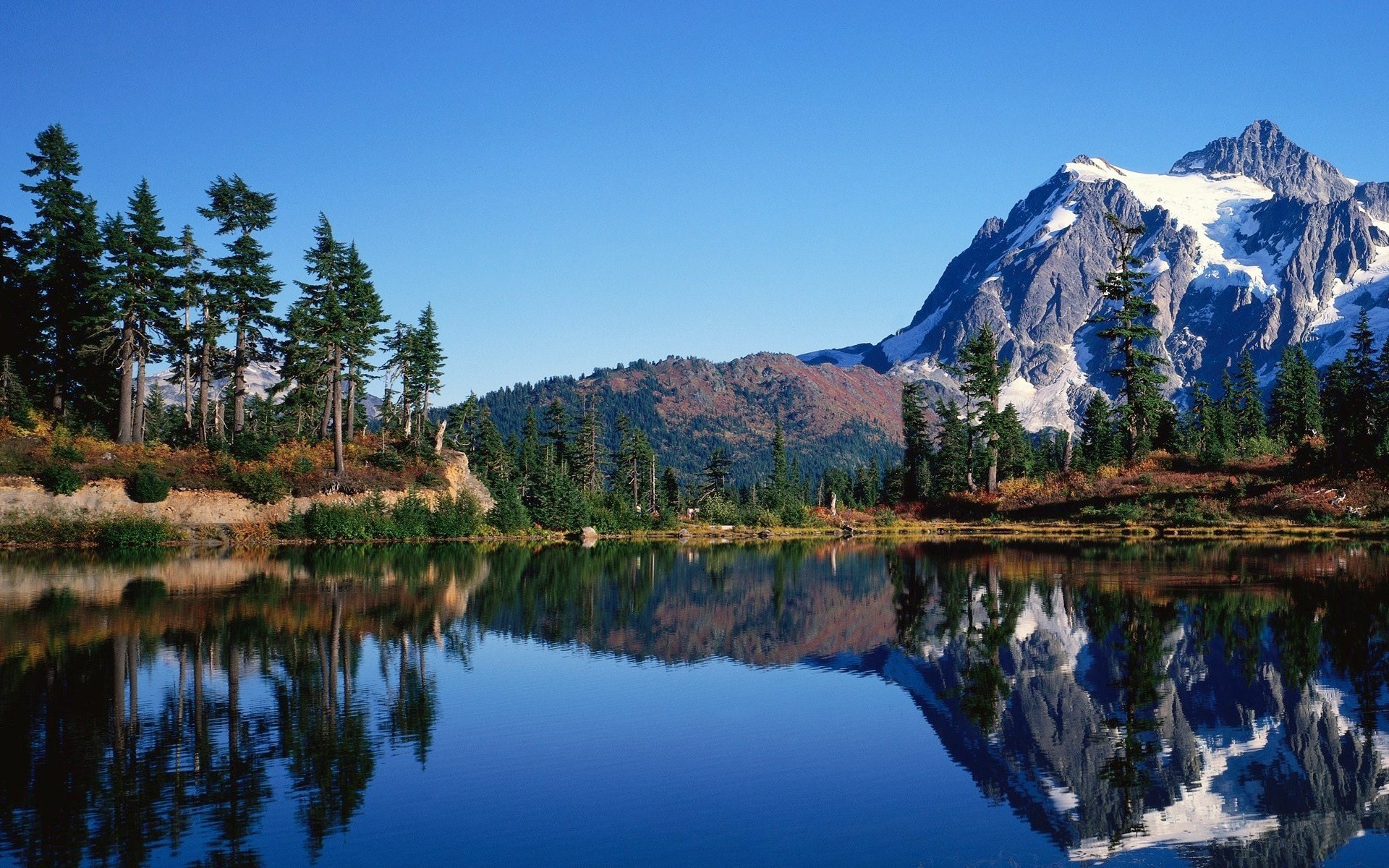 Mountain lake reflection with snow-capped peak and pine trees HD Wallpaper