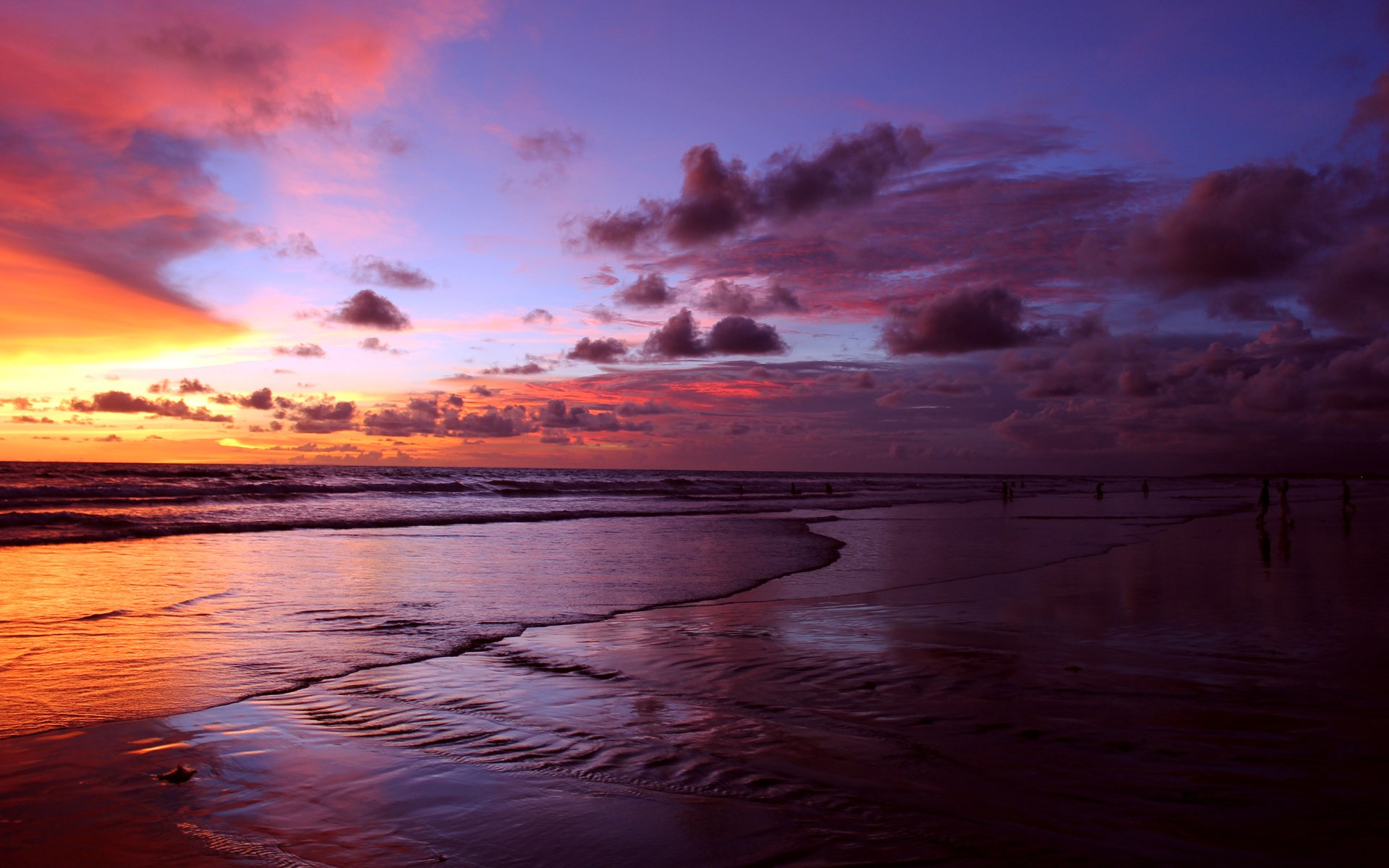 Sunset over a beach with colorful clouds and reflections HD Wallpaper