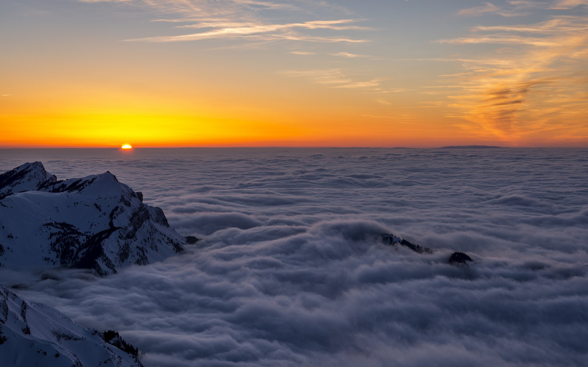 Sunset over clouds with snow-capped mountains HD Wallpaper