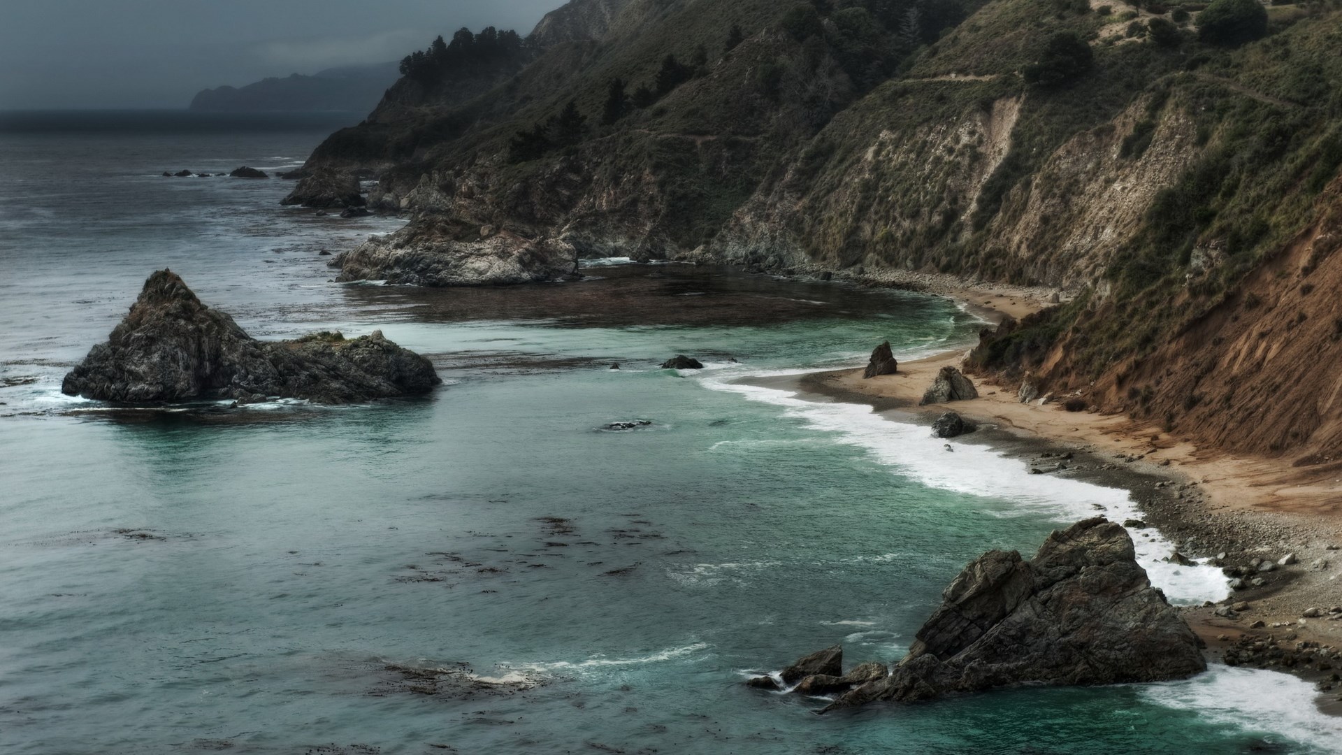 Rocky coastline with crashing waves and a beach HD Wallpaper