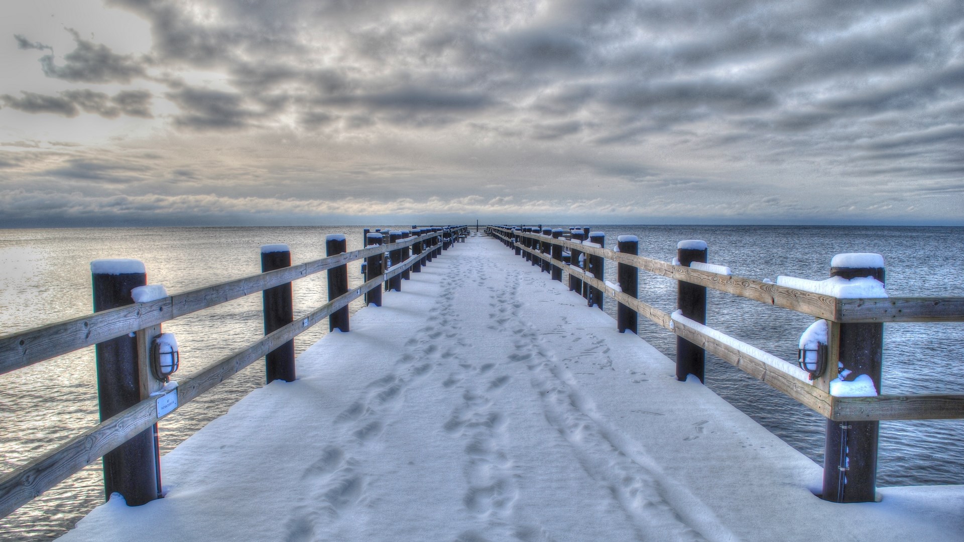 Snowy pier over the water with cloudy sky HD Wallpaper