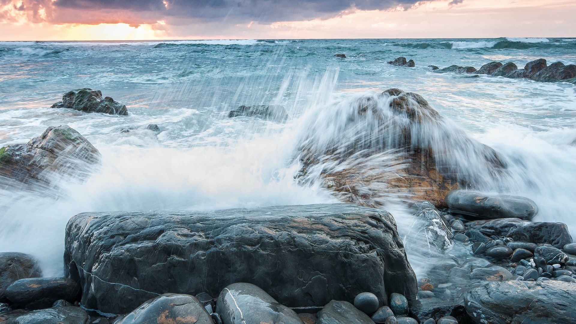Waves crashing on rocky shore at sunset HD Wallpaper