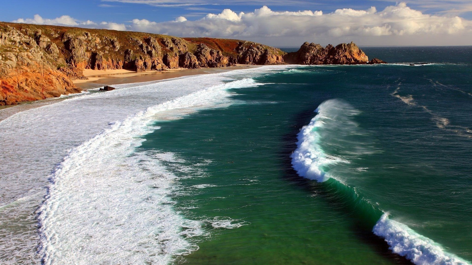 Waves crash on a rocky beach with cliffs HD Wallpaper