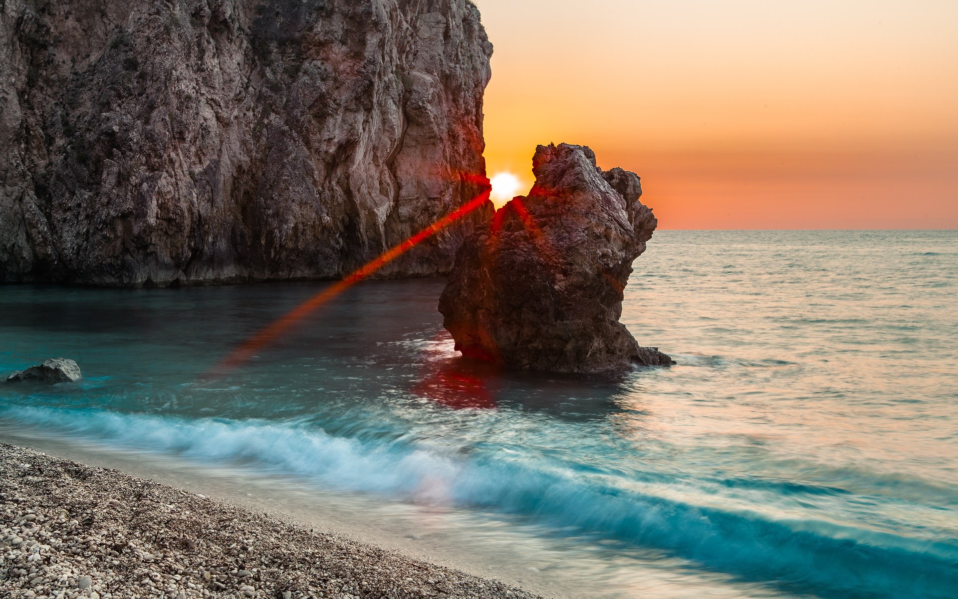 Sunset over rocky coast with waves HD Wallpaper