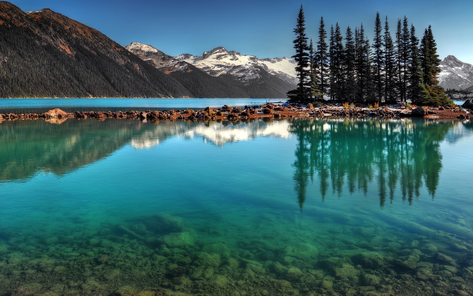 Turquoise lake with rocky island and snow-capped mountains HD Wallpaper