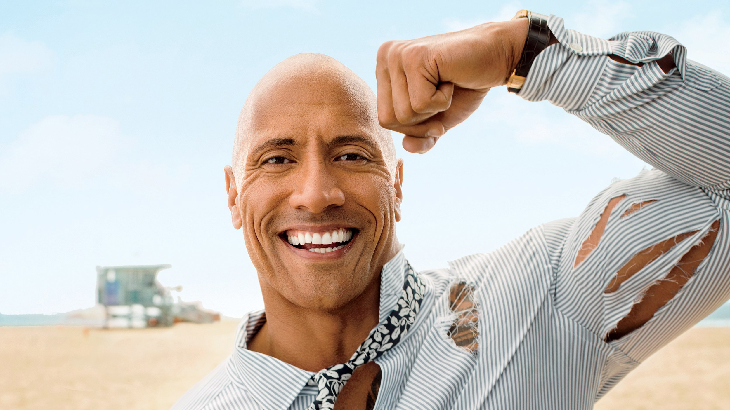Dwayne Johnson flexing on a beach HD Wallpaper