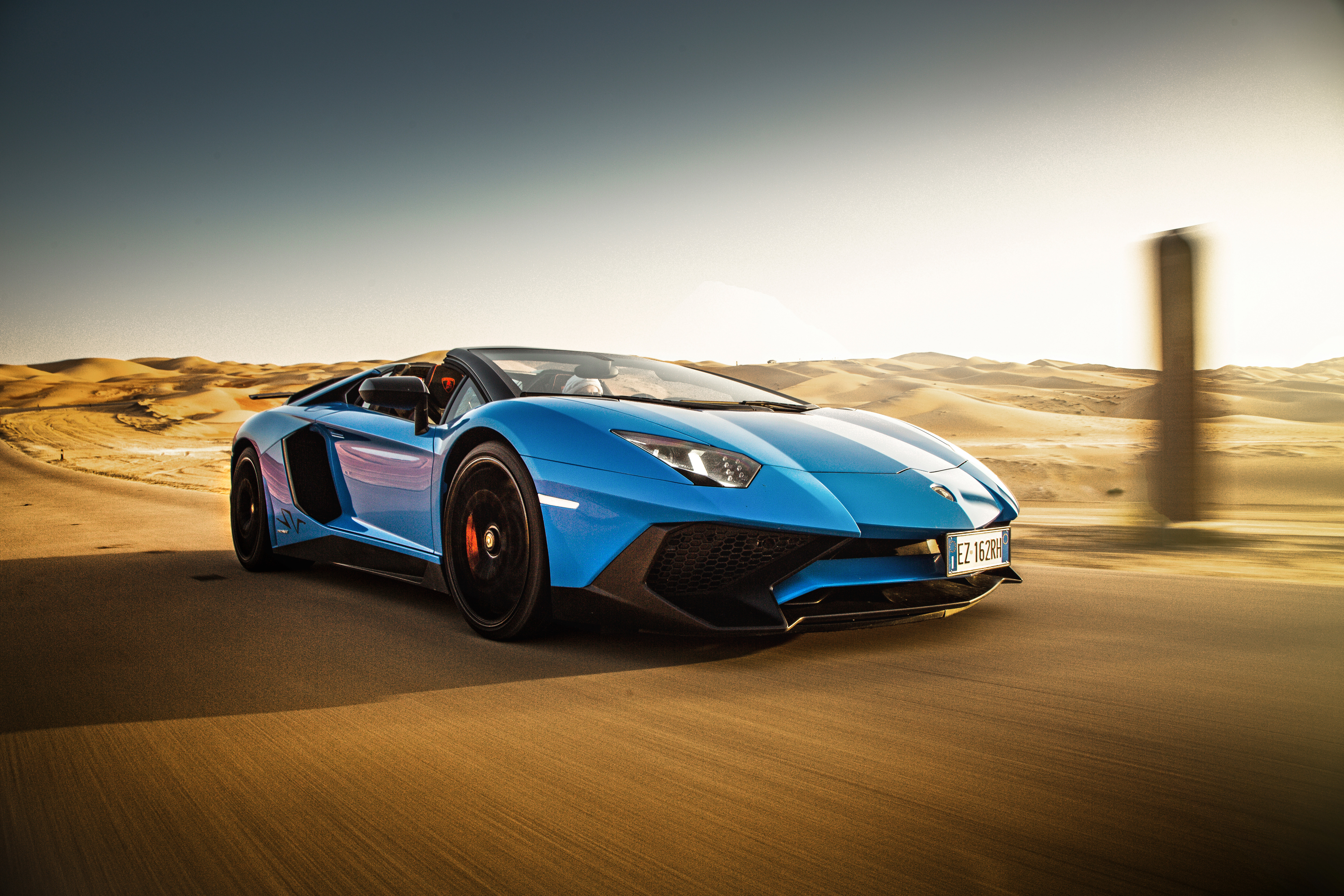 Blue Lamborghini Aventador driving in desert HD Wallpaper