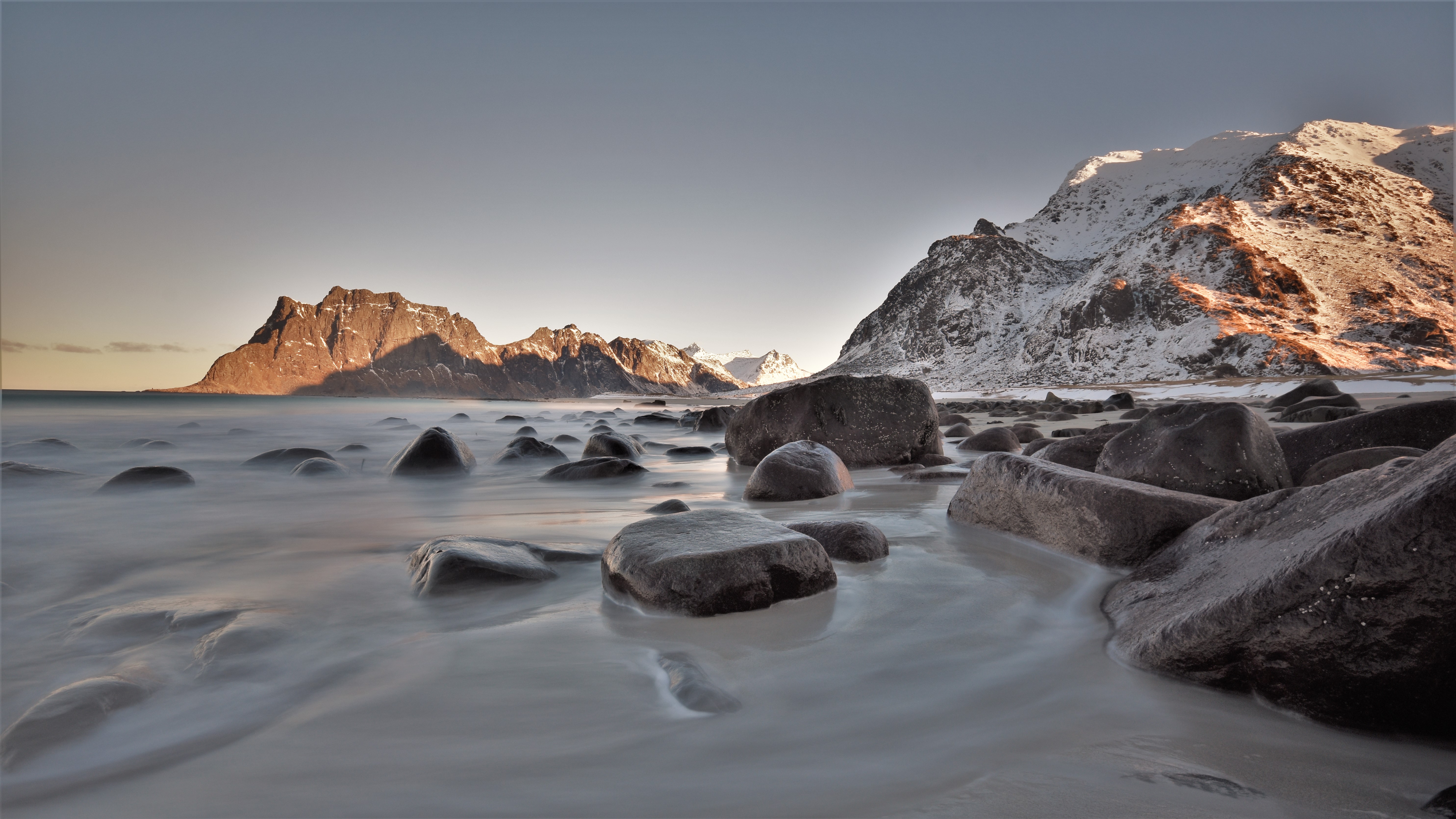 Rocky beach with mountains and sea, long exposure HD Wallpaper