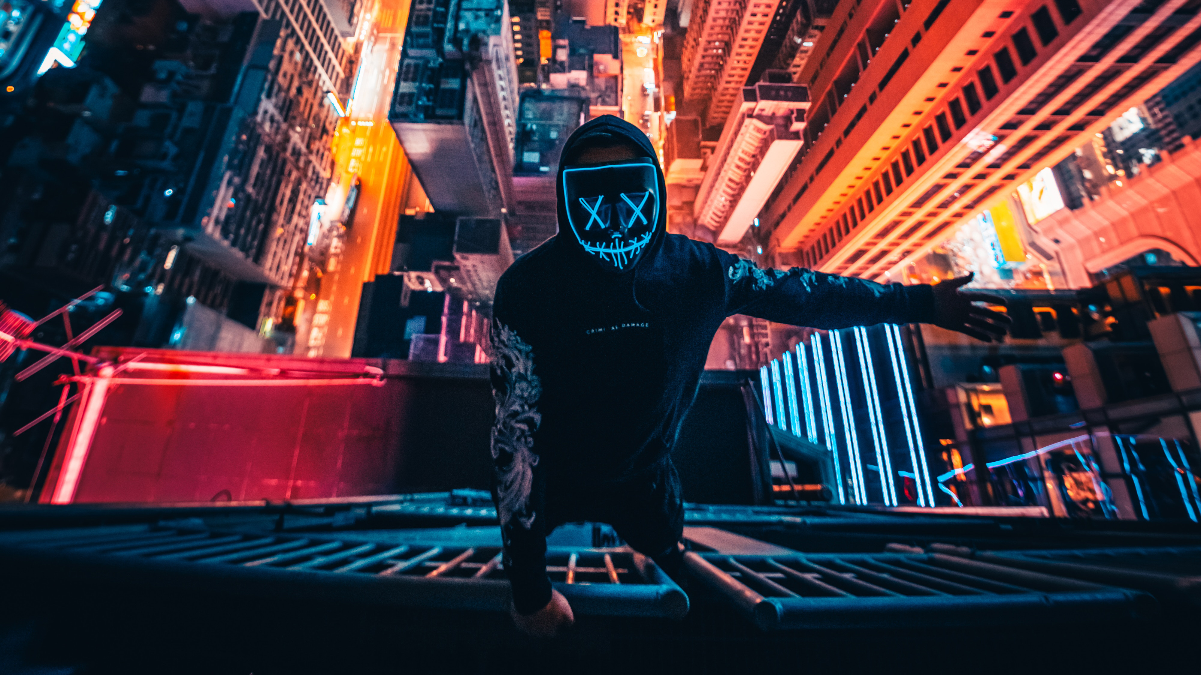 Person wearing a neon mask on a rooftop at night HD Wallpaper