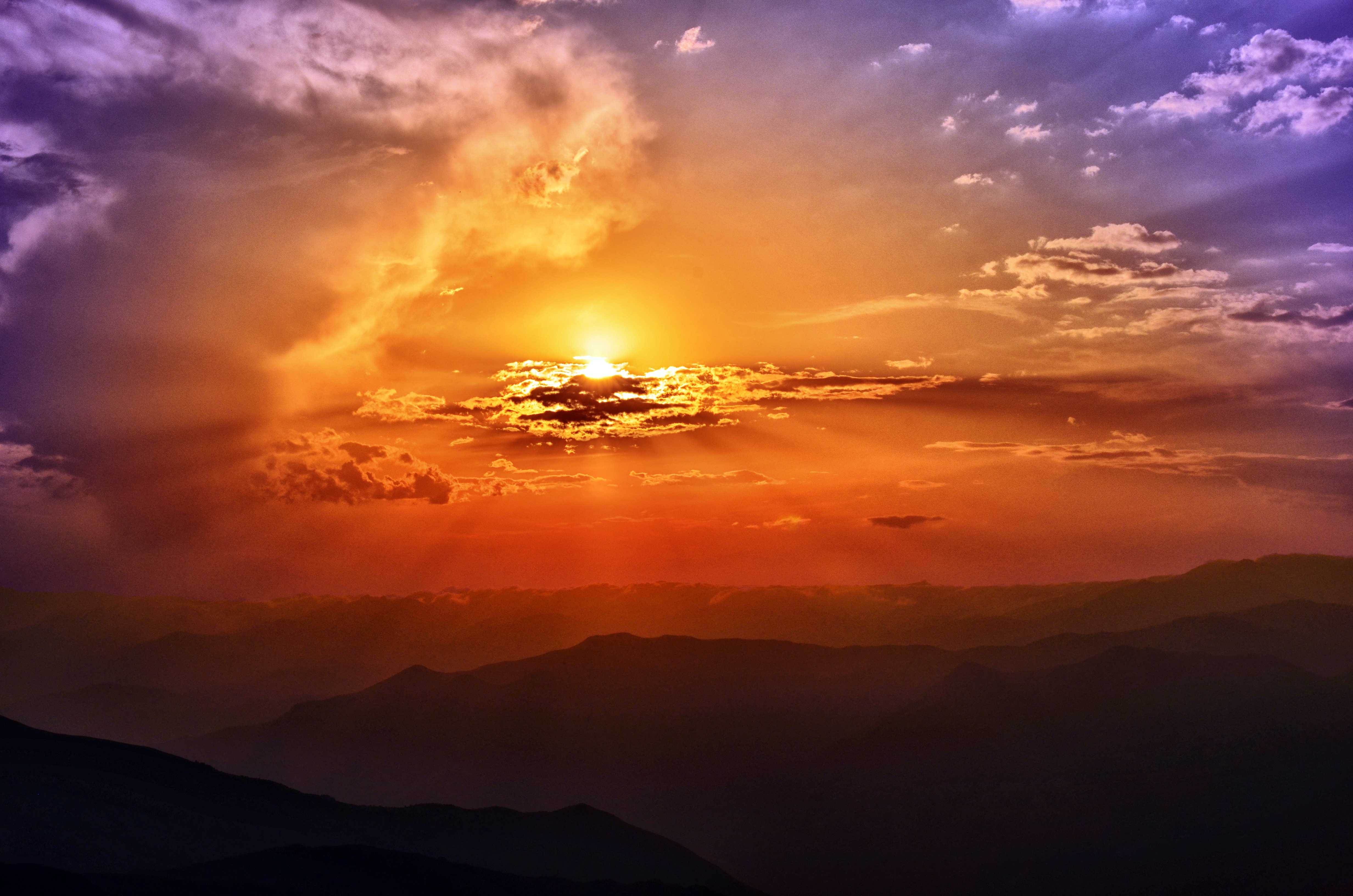 Sunset over mountain ranges with colorful clouds HD Wallpaper