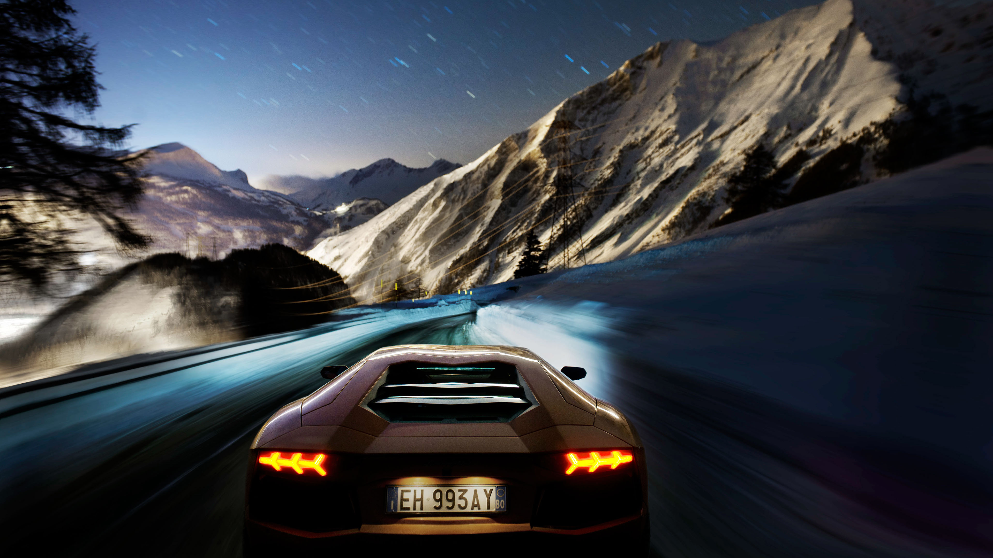 Lamborghini Aventador driving on a snowy mountain road at night HD Wallpaper