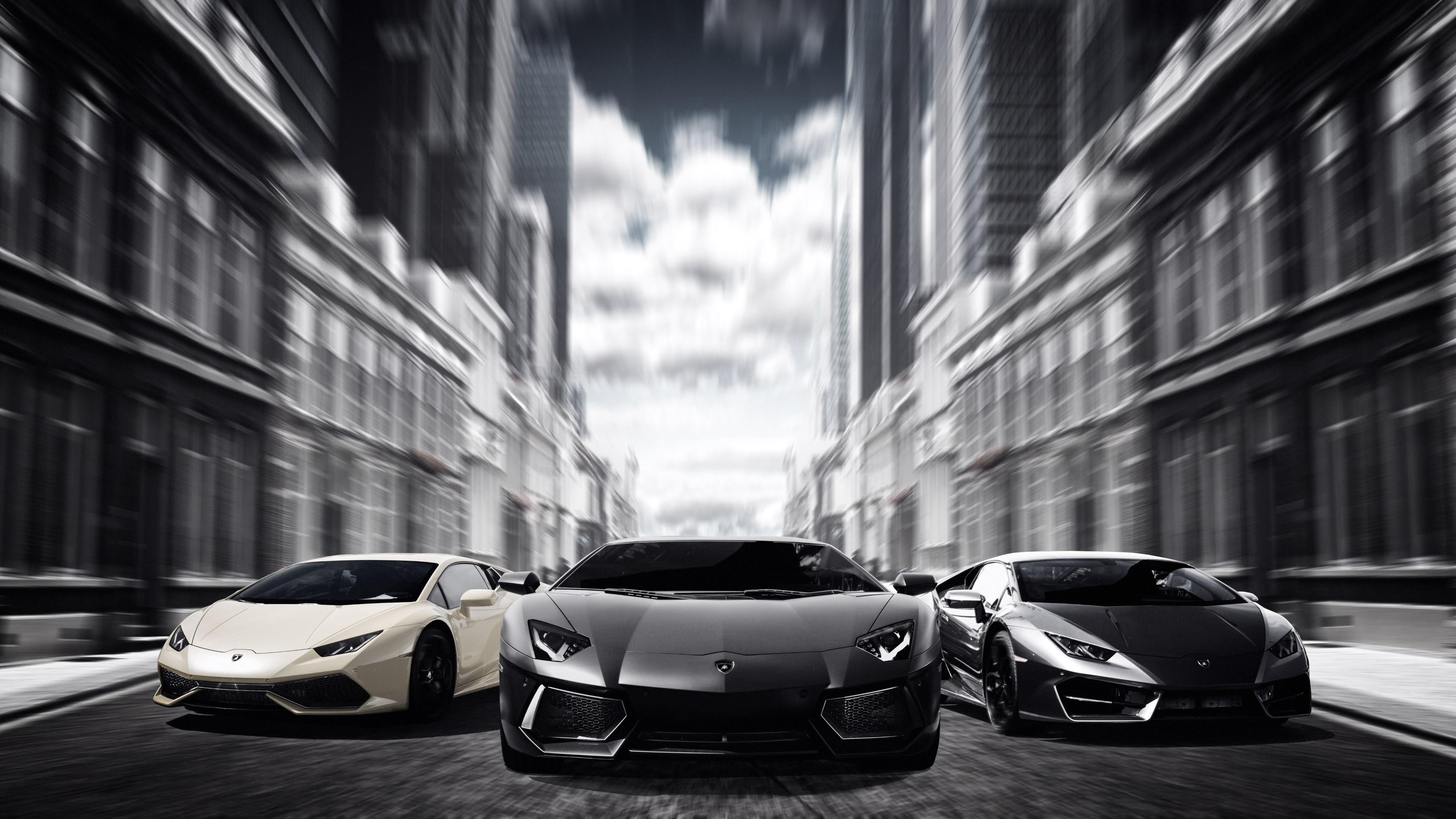 Three Lamborghinis driving down a city street HD Wallpaper