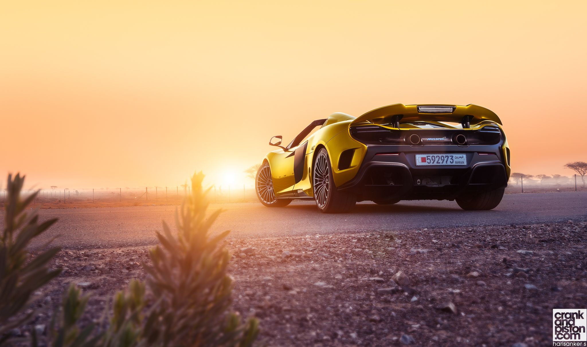 Yellow McLaren sports car on a road at sunset HD Wallpaper